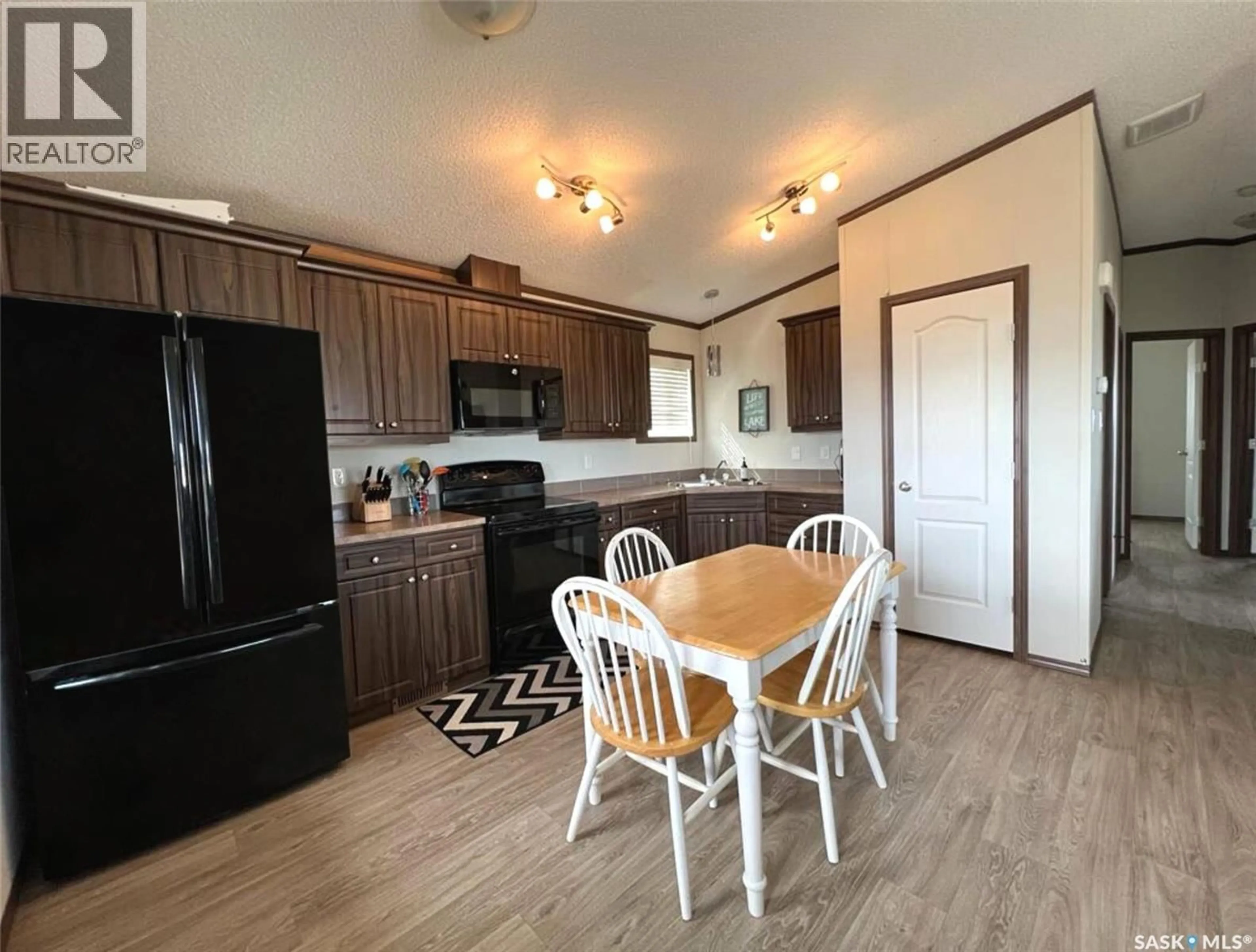 Open concept kitchen, wood/laminate floor for 701 PEBBLE DRIVE, Webb Rm No. 138 Saskatchewan S0N2X0