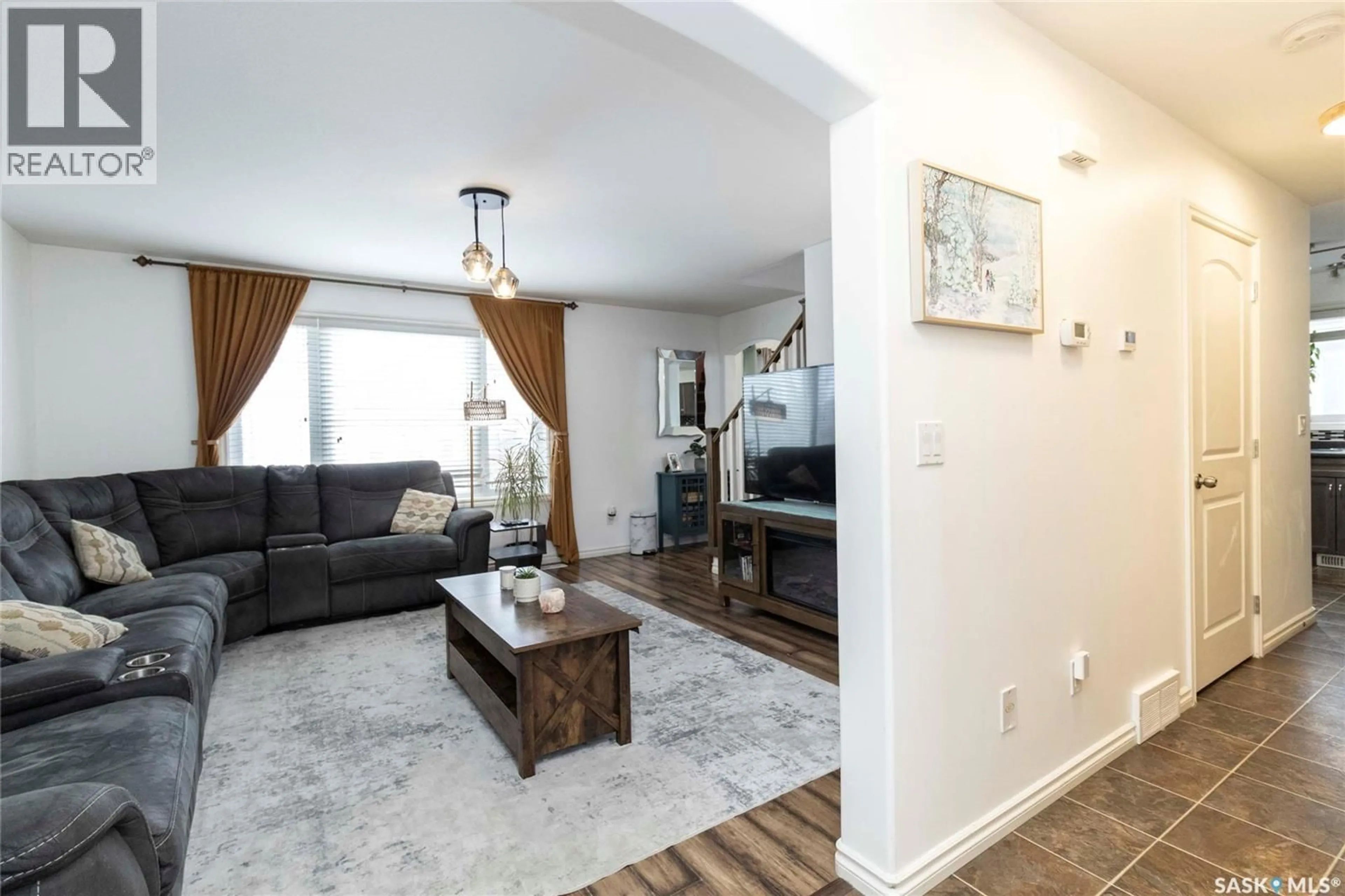Living room with furniture, wood/laminate floor for 227 MACINNES STREET, Saskatoon Saskatchewan S7T0L6