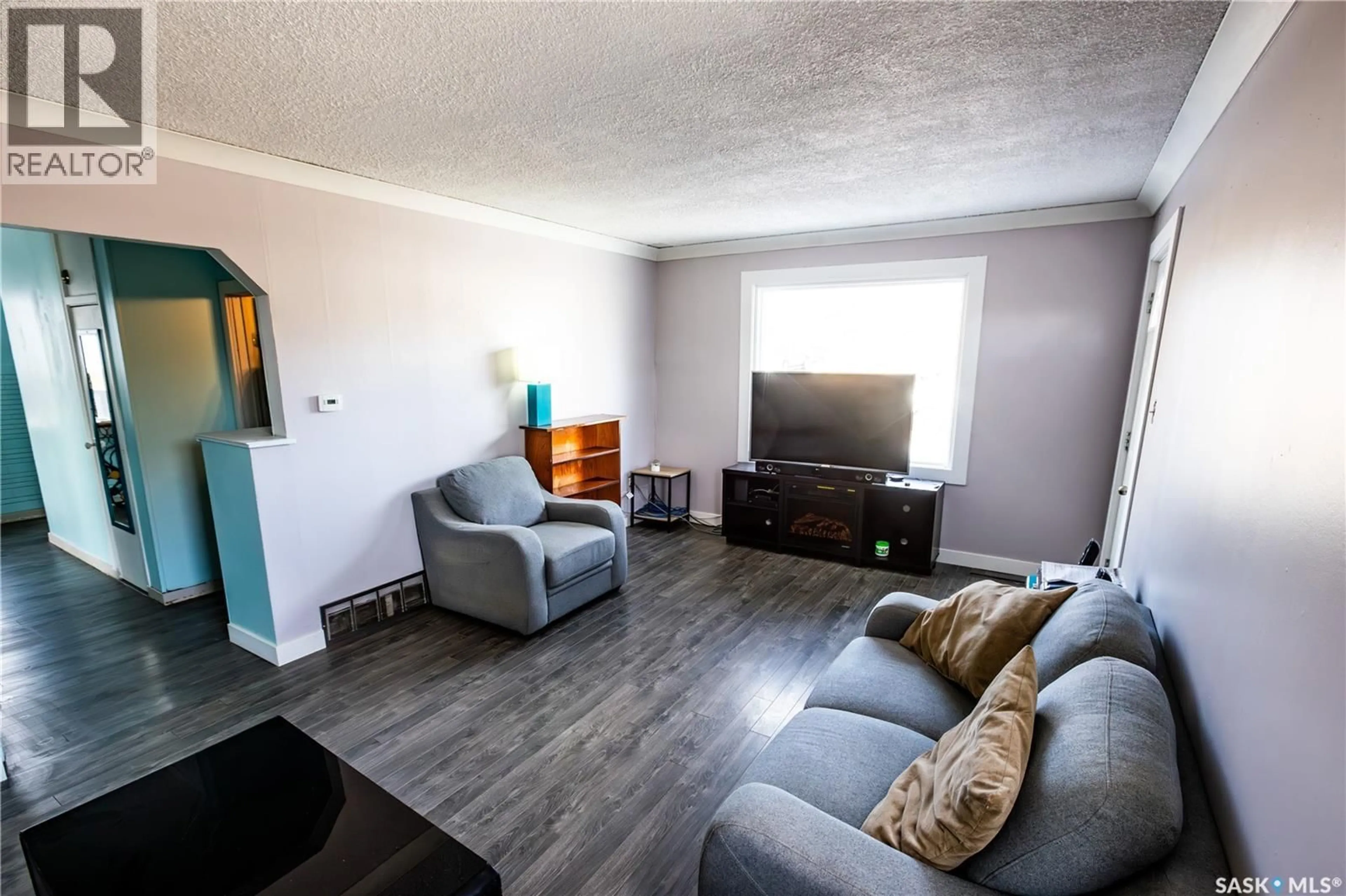 Living room with furniture, wood/laminate floor for 1021 CARIBOU STREET W, Moose Jaw Saskatchewan S6H2L6