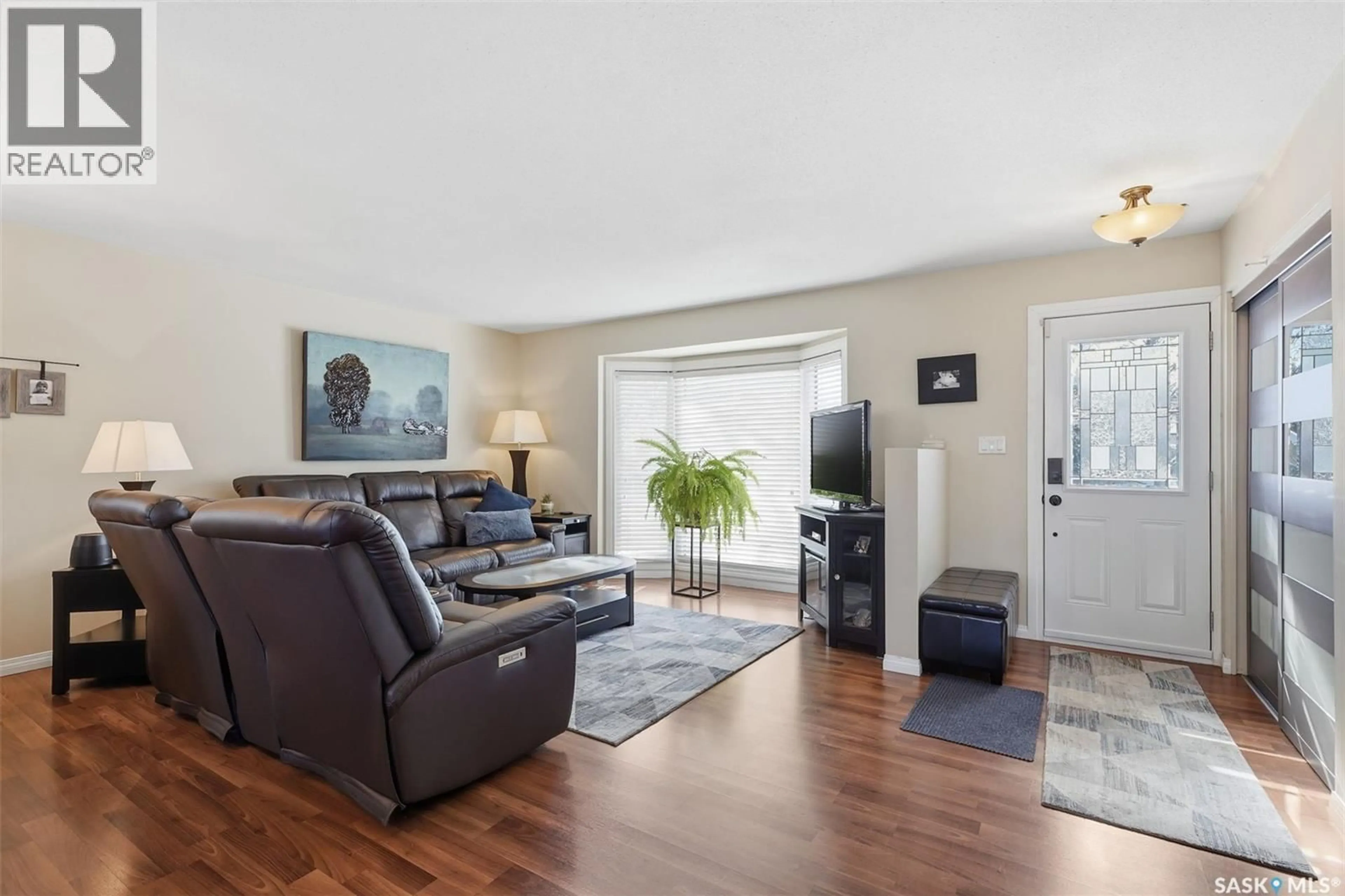 Living room with furniture, wood/laminate floor for 138 QUILL CRESCENT, Saskatoon Saskatchewan S7K4T9