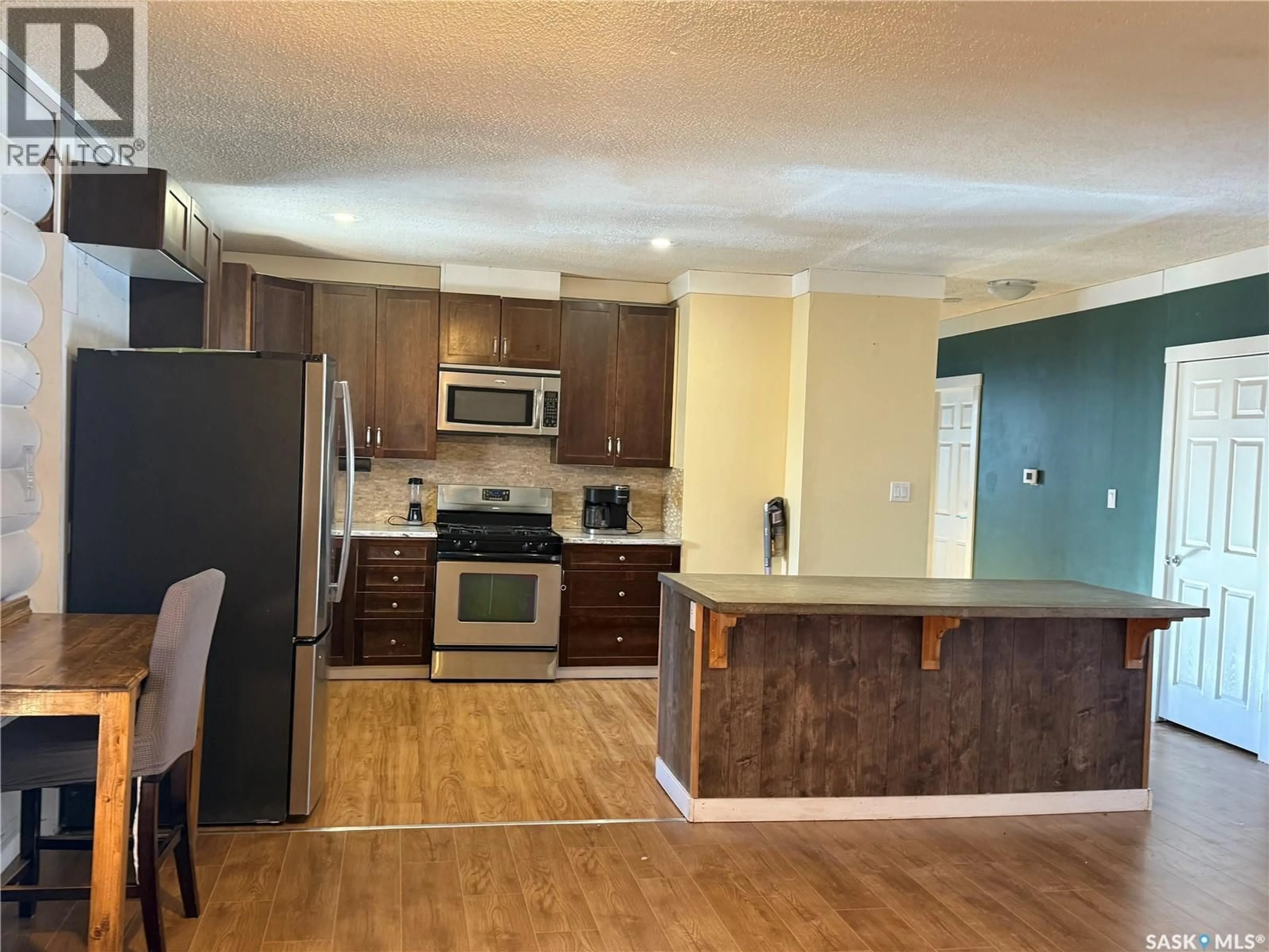 Open concept kitchen, wood/laminate floor for 804 STUDER STREET, La Ronge Saskatchewan S0J1L0