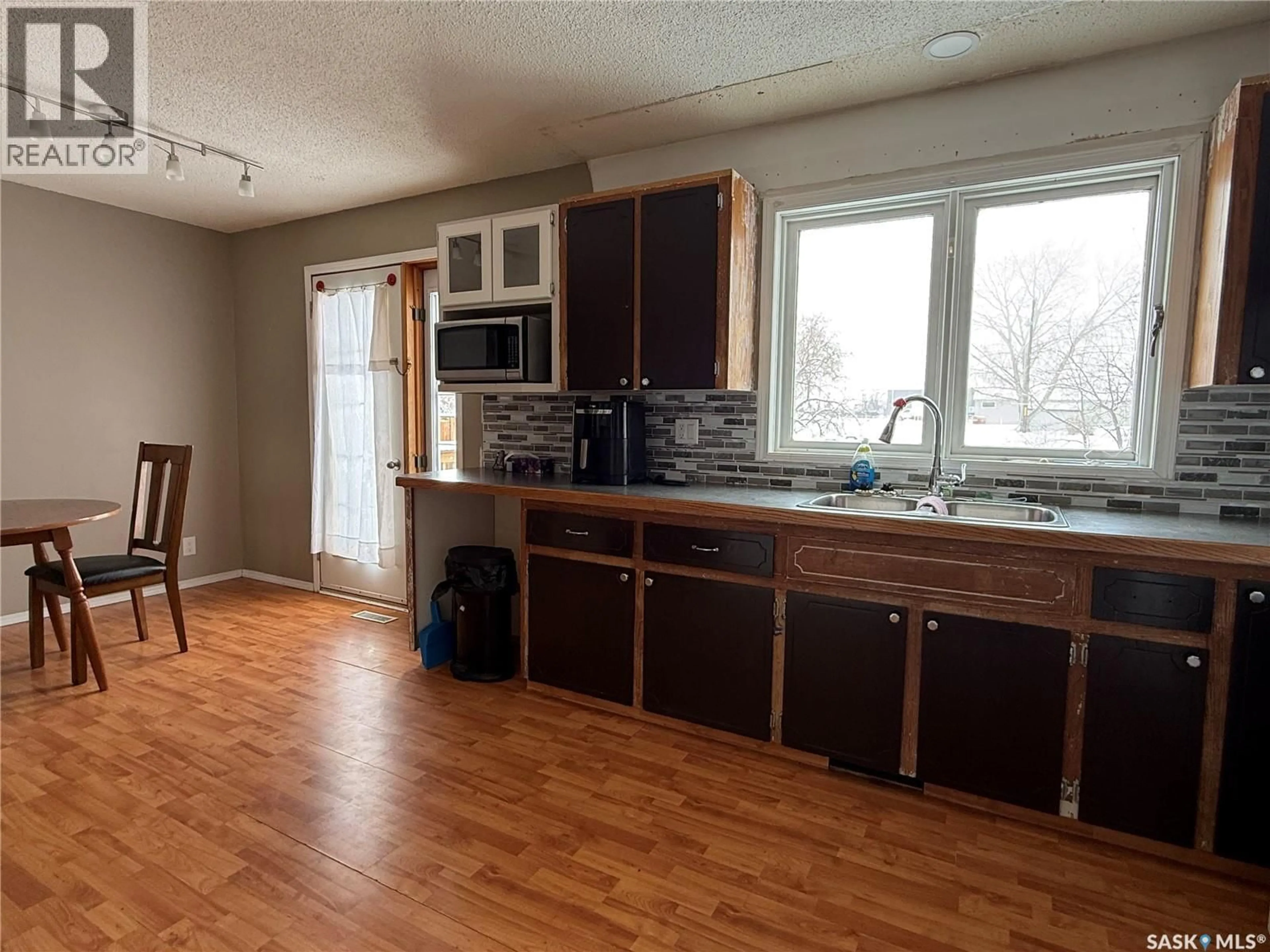 Open concept kitchen, wood/laminate floor for 628 STAVELEY CRESCENT, Weyburn Saskatchewan S4H2T6