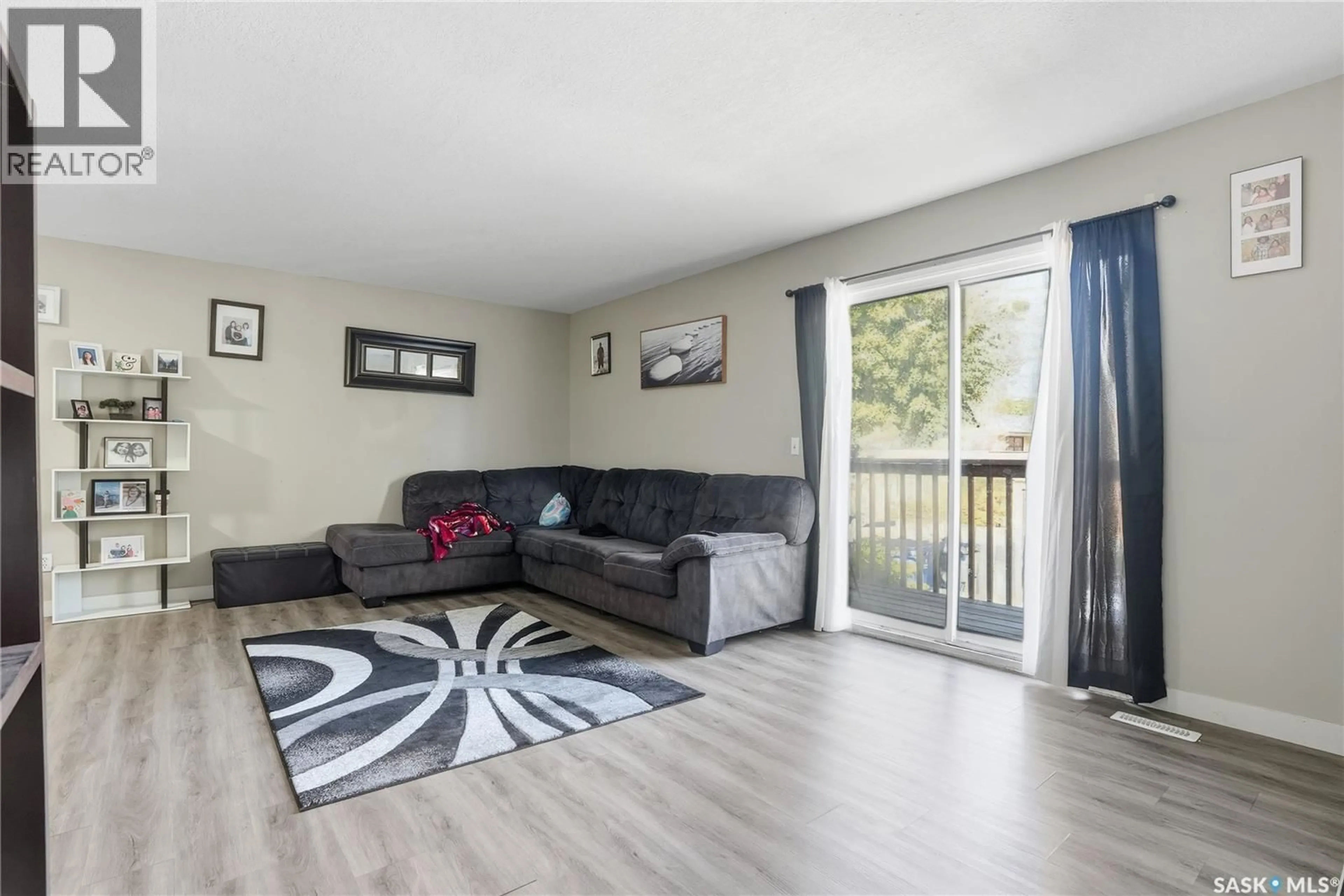 Living room with furniture, wood/laminate floor for 119 - 121 OLMSTEAD ROAD, Saskatoon Saskatchewan S7M4L9