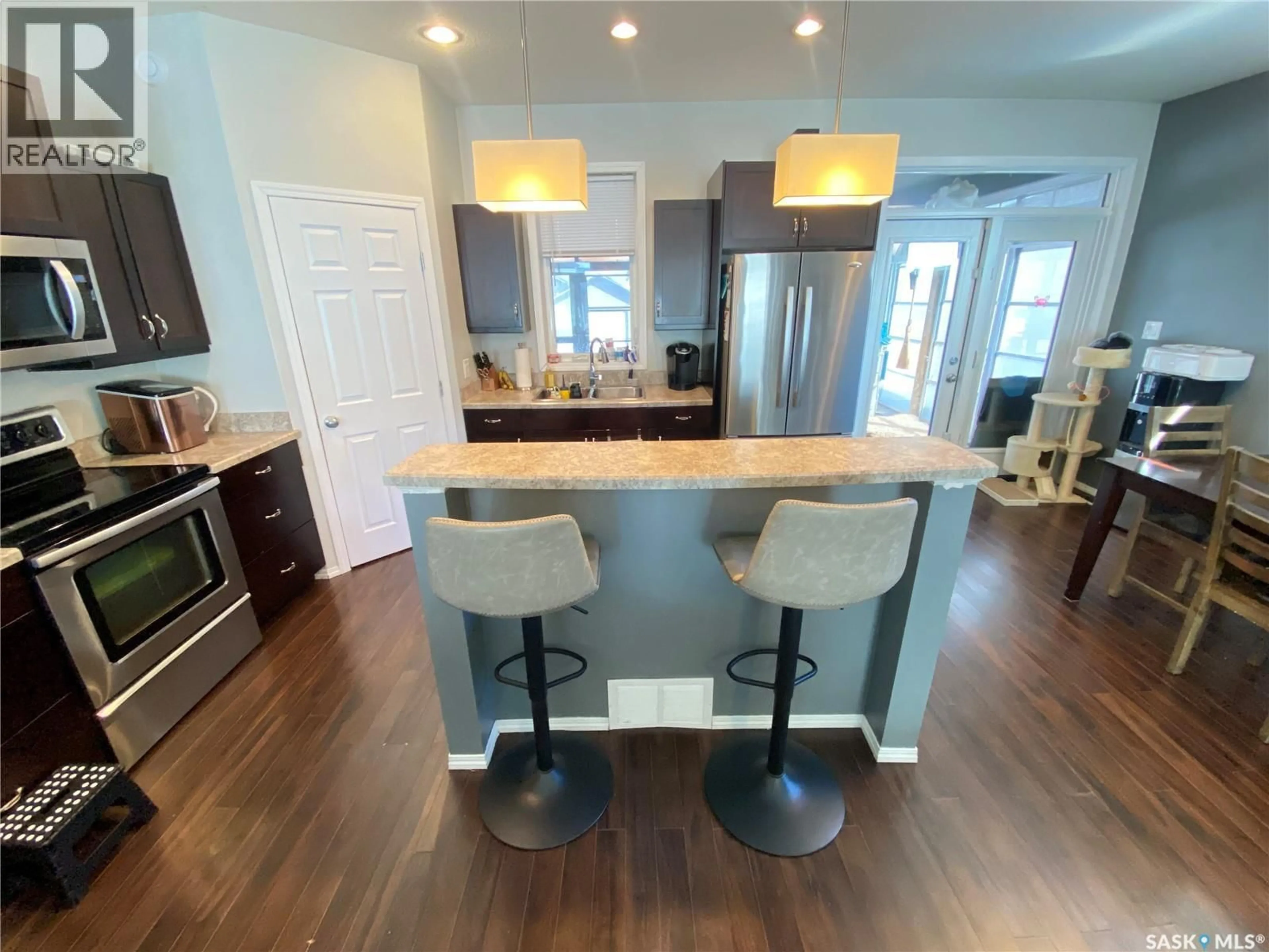 Open concept kitchen, wood/laminate floor for 703 BARBER CRESCENT, Weyburn Saskatchewan S4H0B9