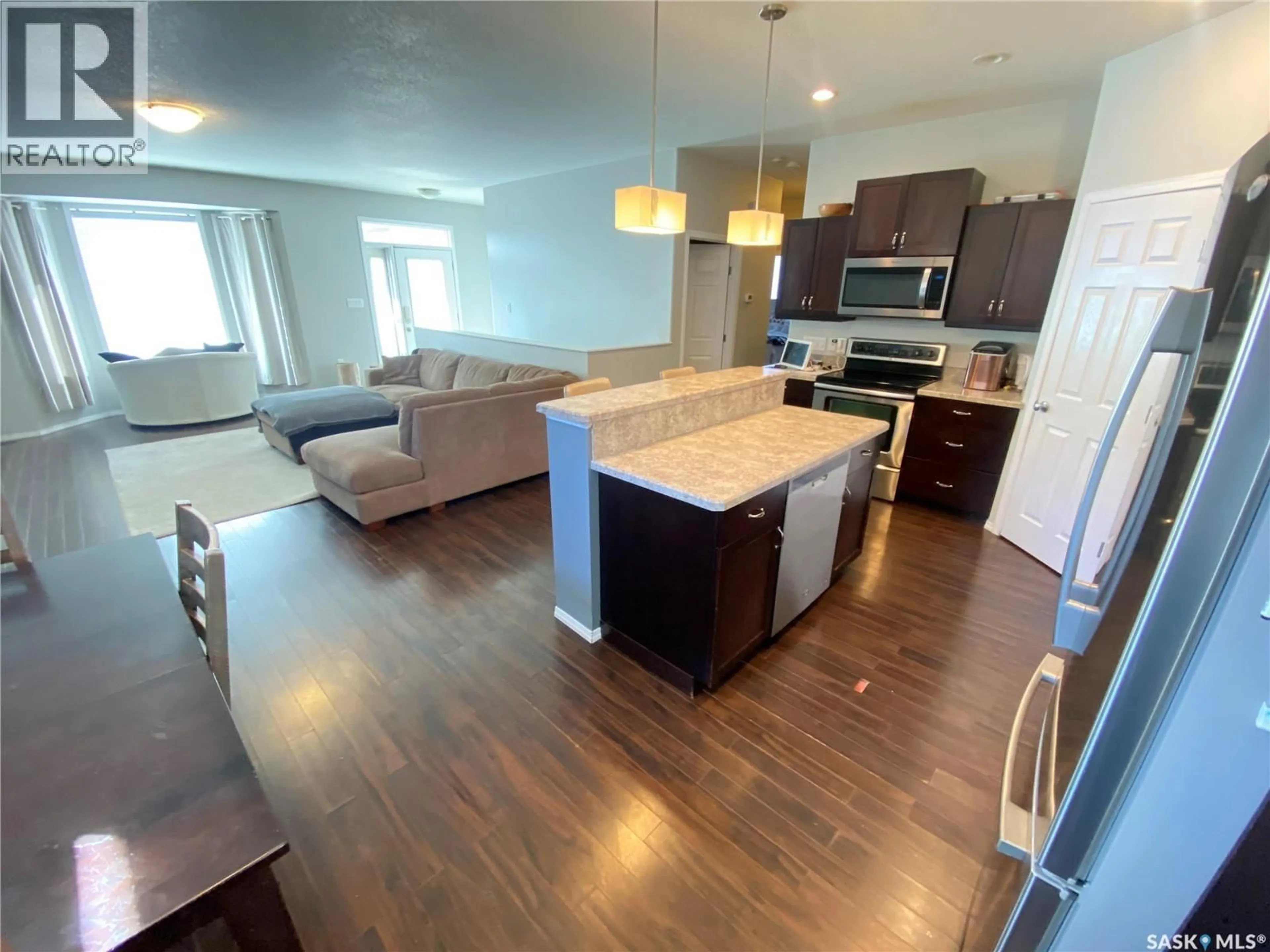 Open concept kitchen, wood/laminate floor for 703 BARBER CRESCENT, Weyburn Saskatchewan S4H0B9