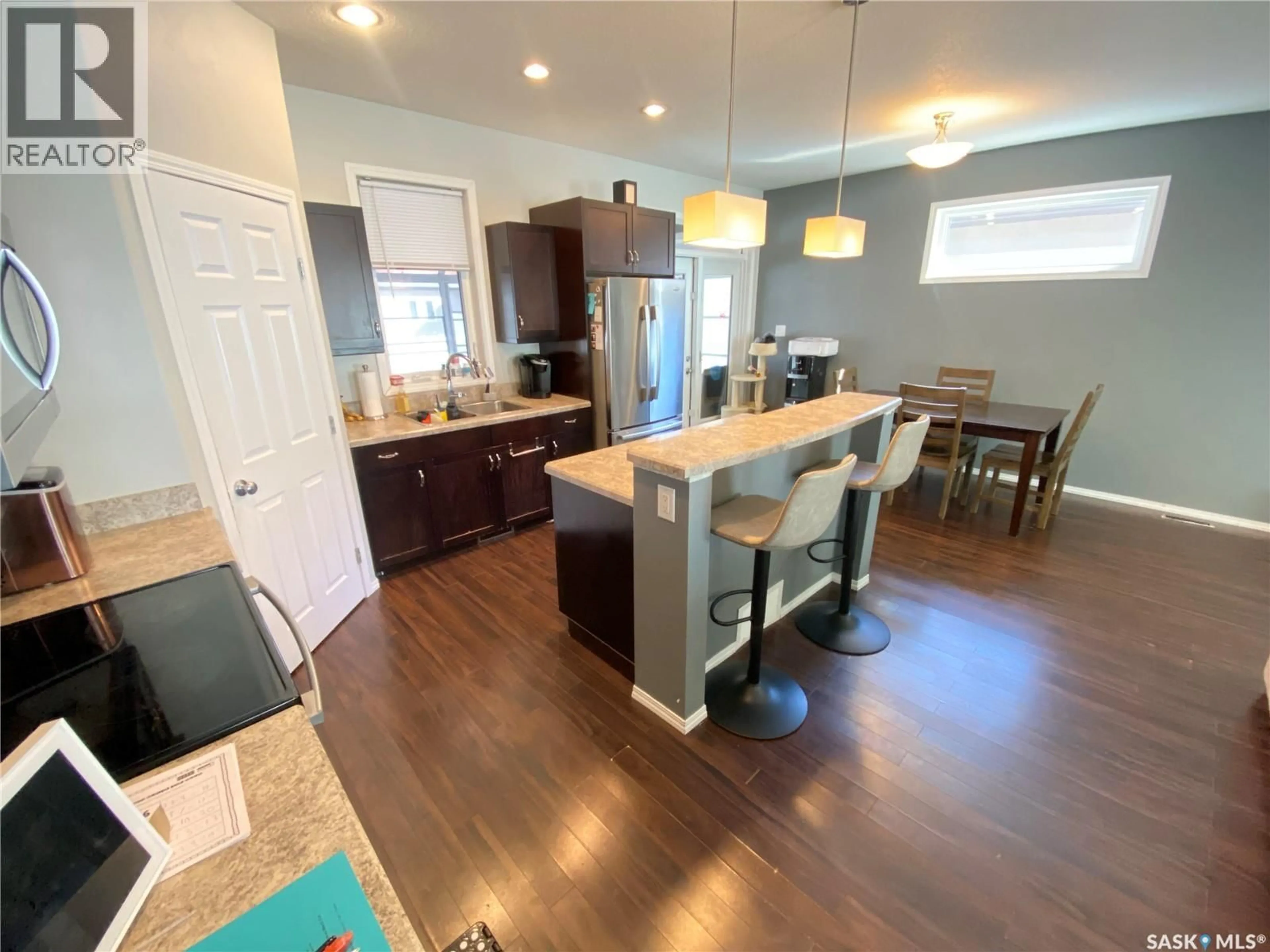 Open concept kitchen, wood/laminate floor for 703 BARBER CRESCENT, Weyburn Saskatchewan S4H0B9