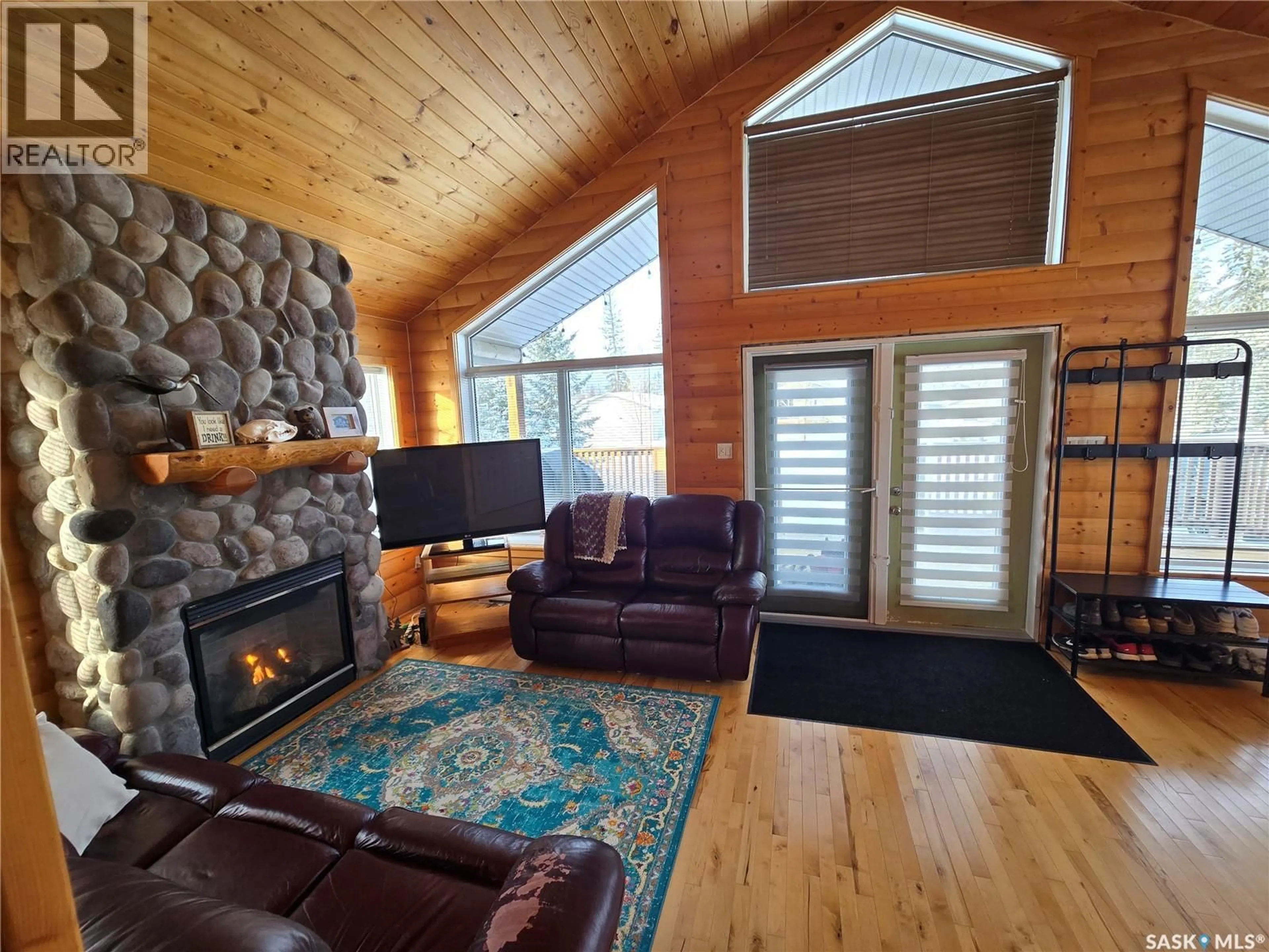 Living room with furniture, wood/laminate floor for 34 AIRPORT DRIVE, Candle Lake Saskatchewan S0J3E0