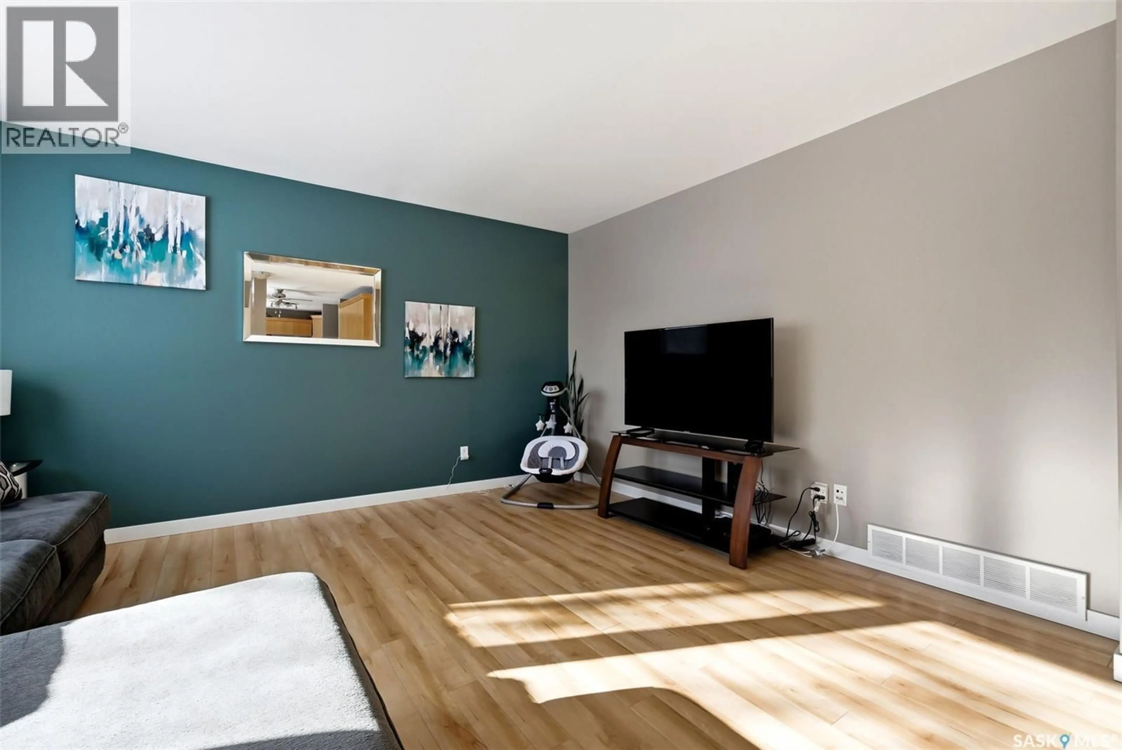 Living room with furniture, wood/laminate floor for 22 SIBBALD CRESCENT, Regina Saskatchewan S4T7L7