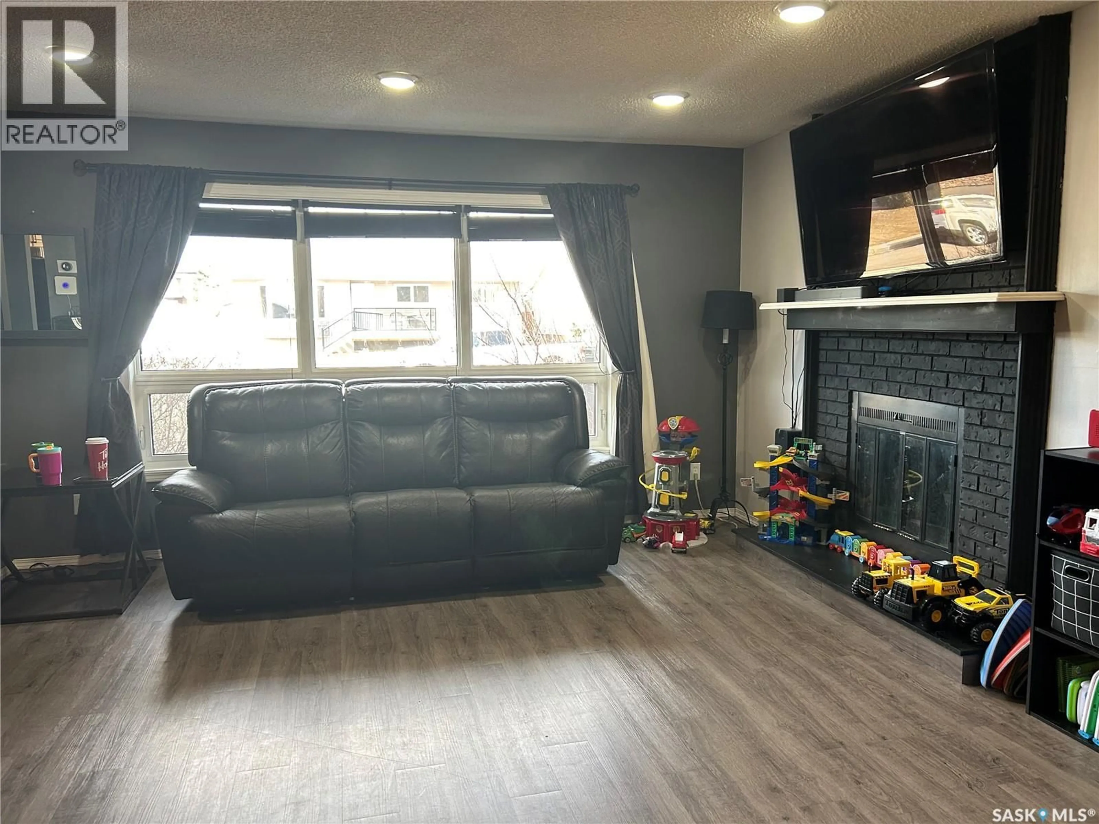 Living room with furniture, wood/laminate floor for 488 WILLOW BAY, Estevan Saskatchewan S4A2G4