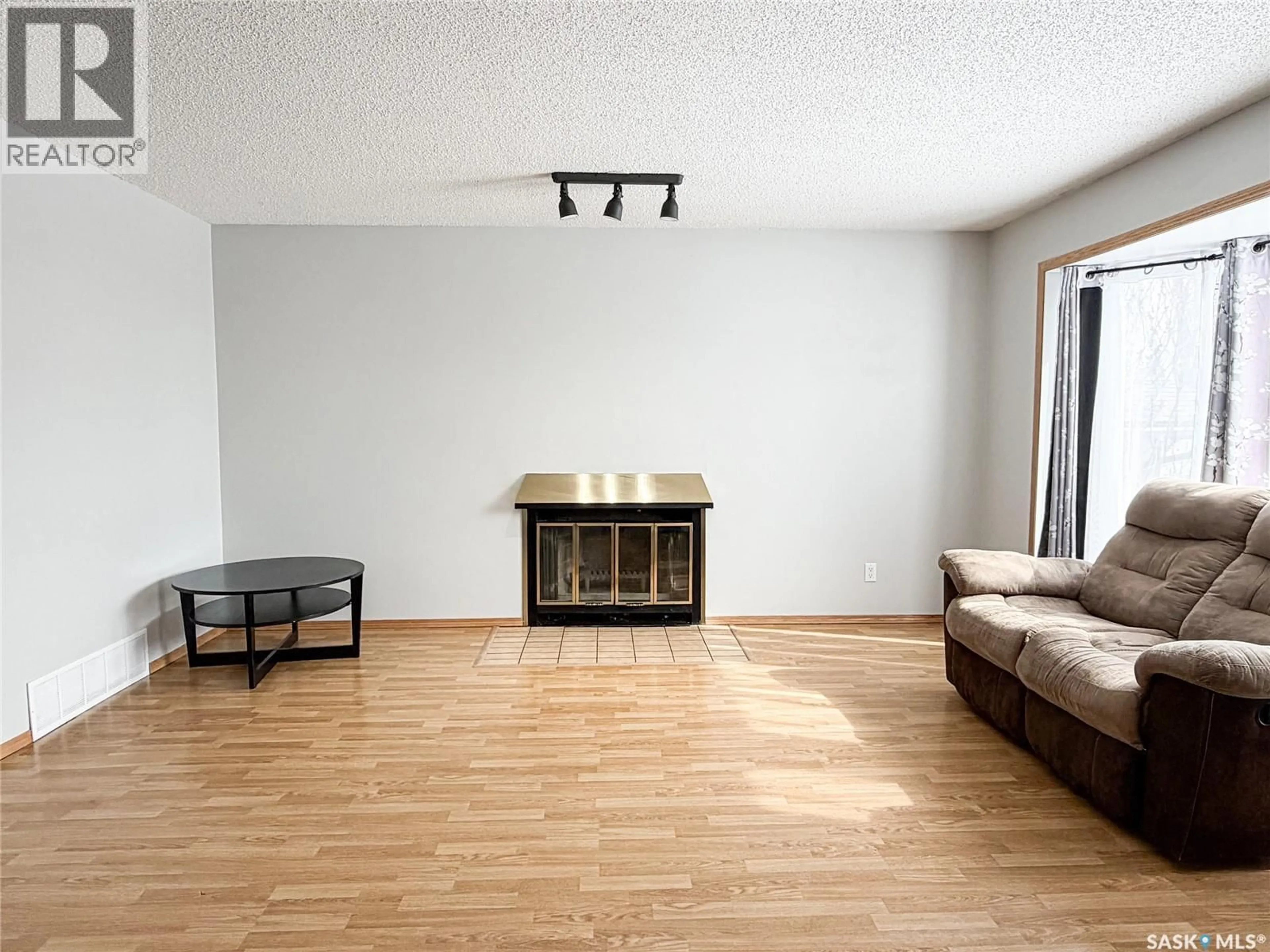 Living room with furniture, wood/laminate floor for 503 6TH AVENUE, Meadow Lake Saskatchewan S9X1B9