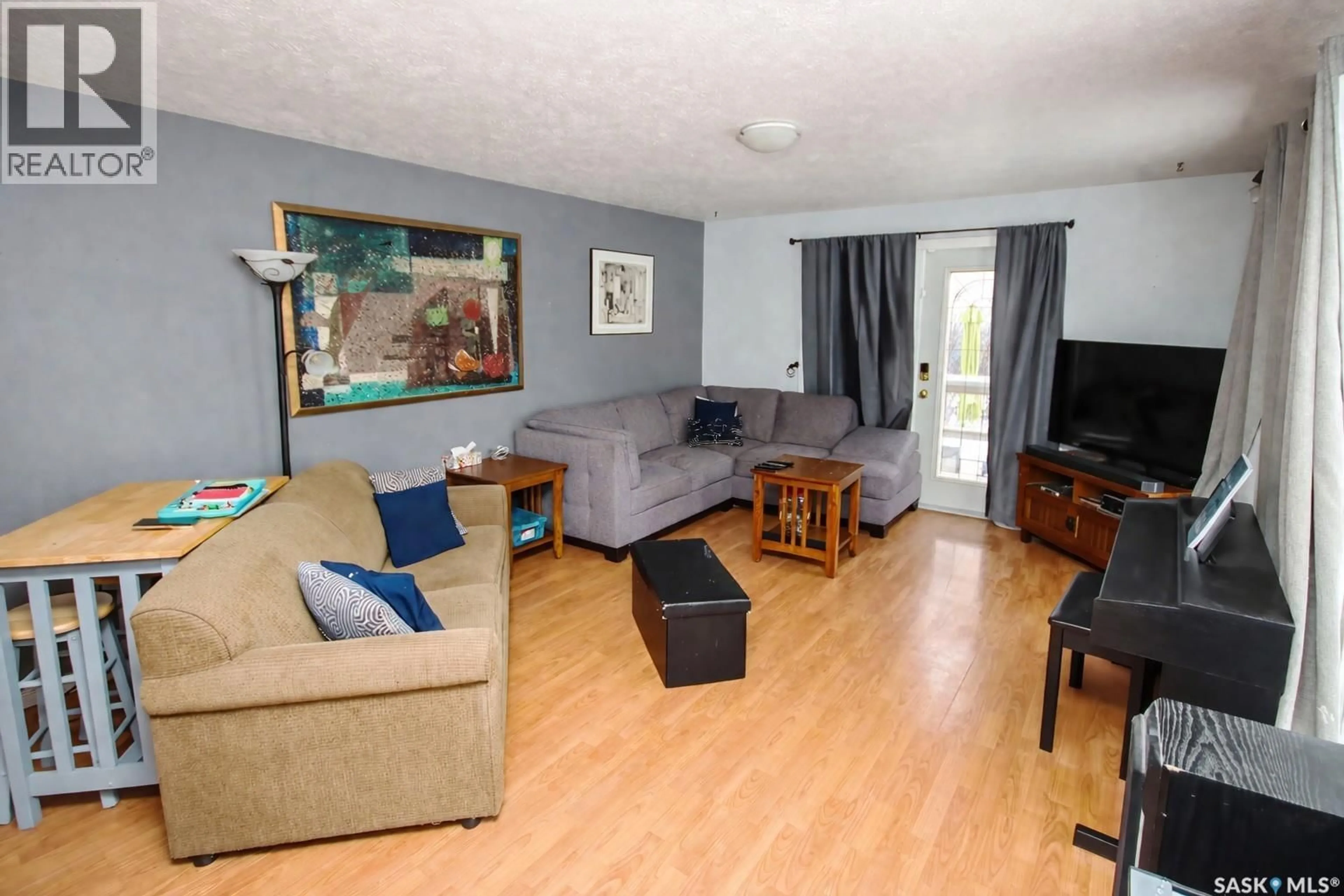 Living room with furniture, wood/laminate floor for 560 TALLMAN STREET, Macoun Saskatchewan S0C1P0