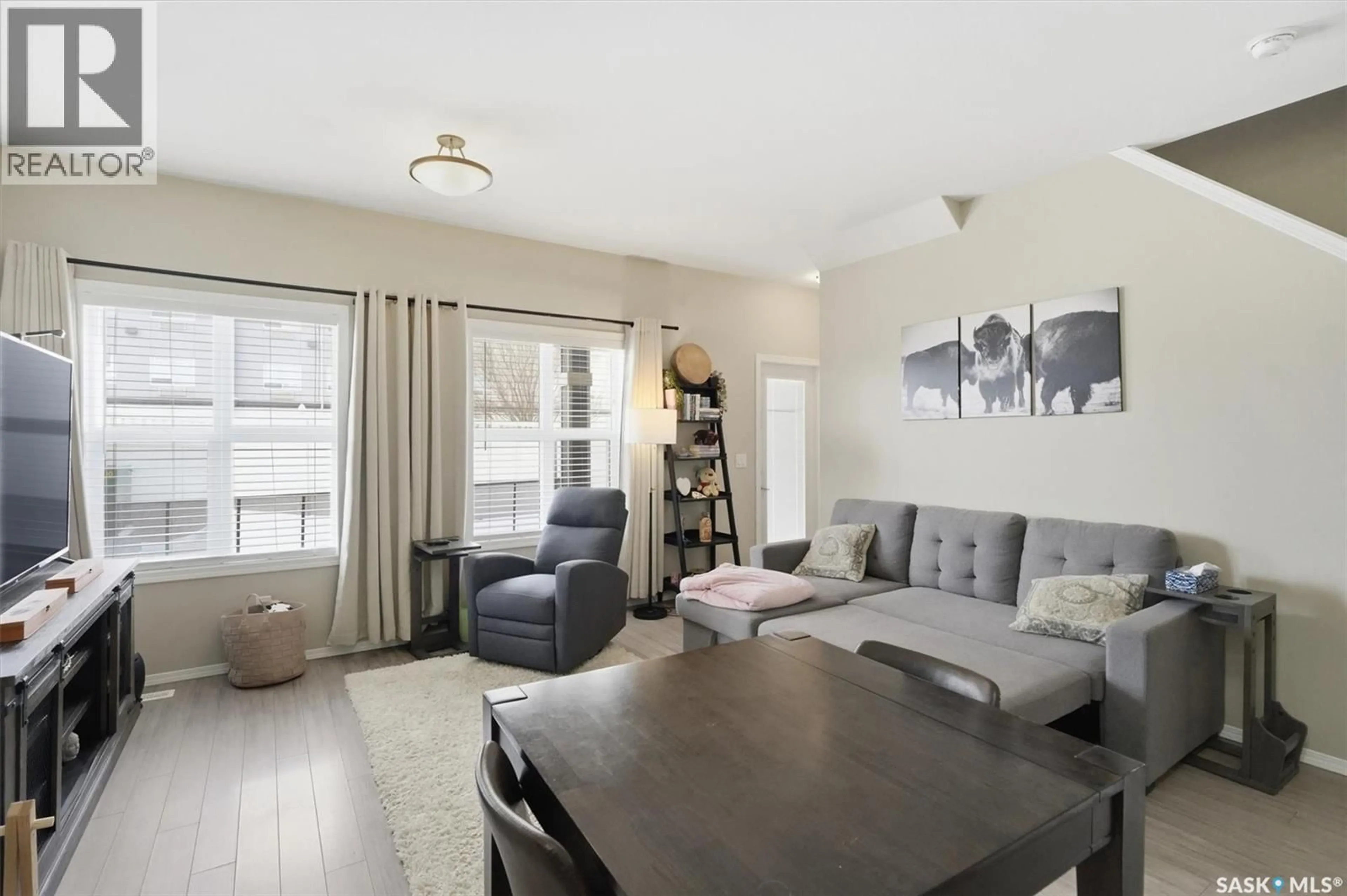 Living room with furniture, wood/laminate floor for 100 - 114 CHAPARRAL BOULEVARD, Martensville Saskatchewan S0K0A2