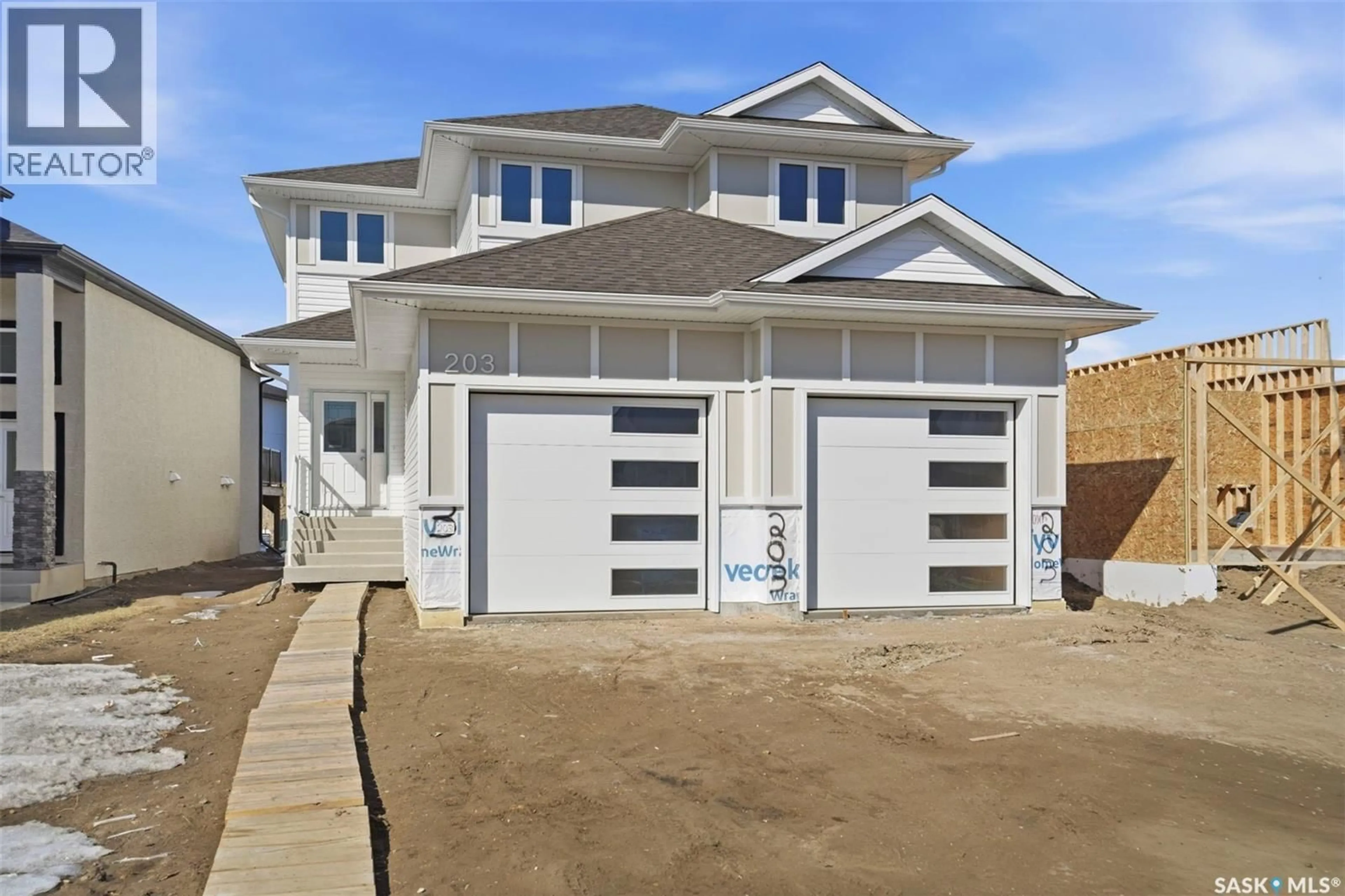 Home with vinyl exterior material, street for 203 SHARMA LANE, Saskatoon Saskatchewan S7W0Y4