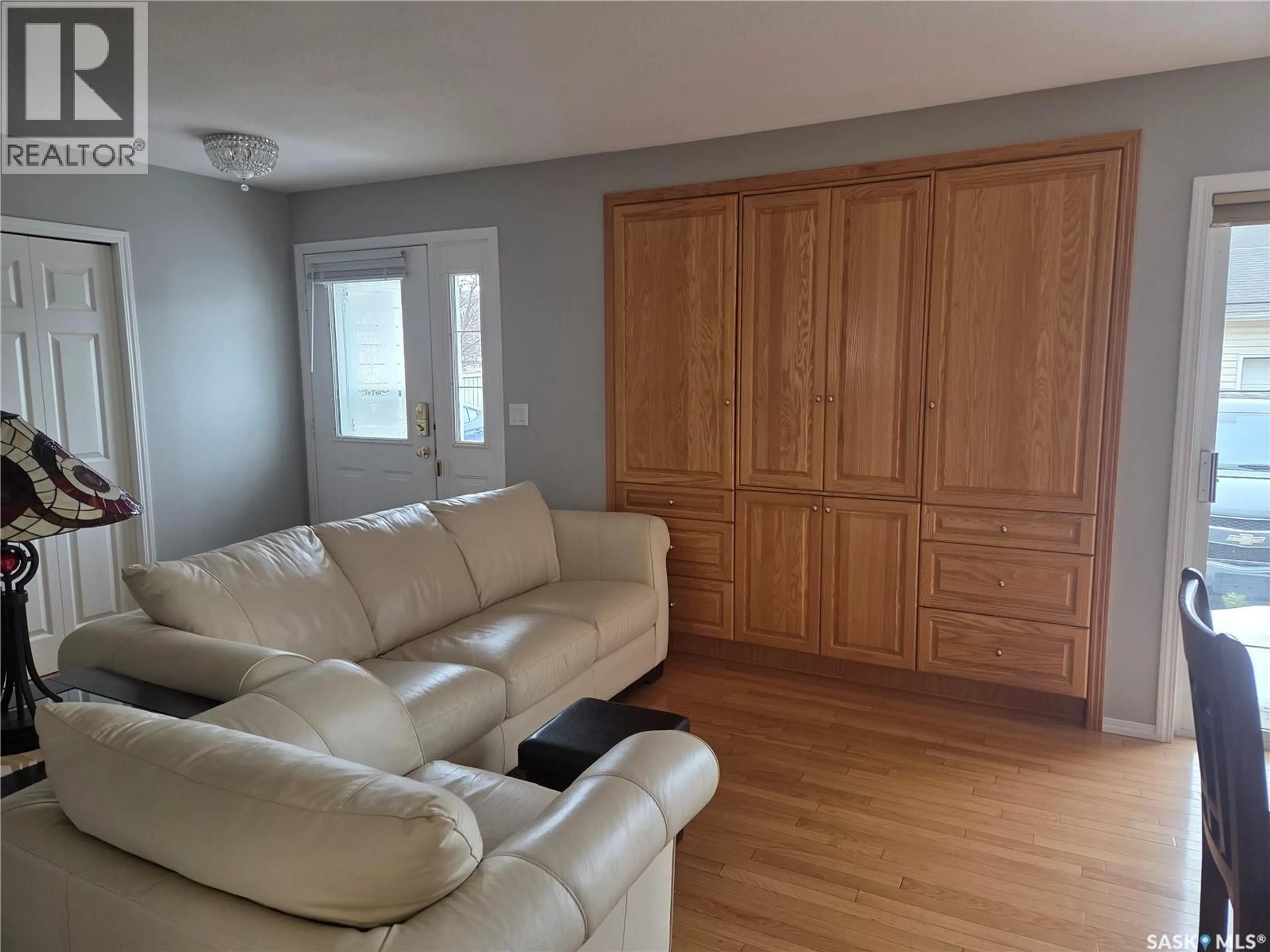 Living room with furniture, wood/laminate floor for 102A 425 KEEVIL CRESCENT, Saskatoon Saskatchewan S7N4R9