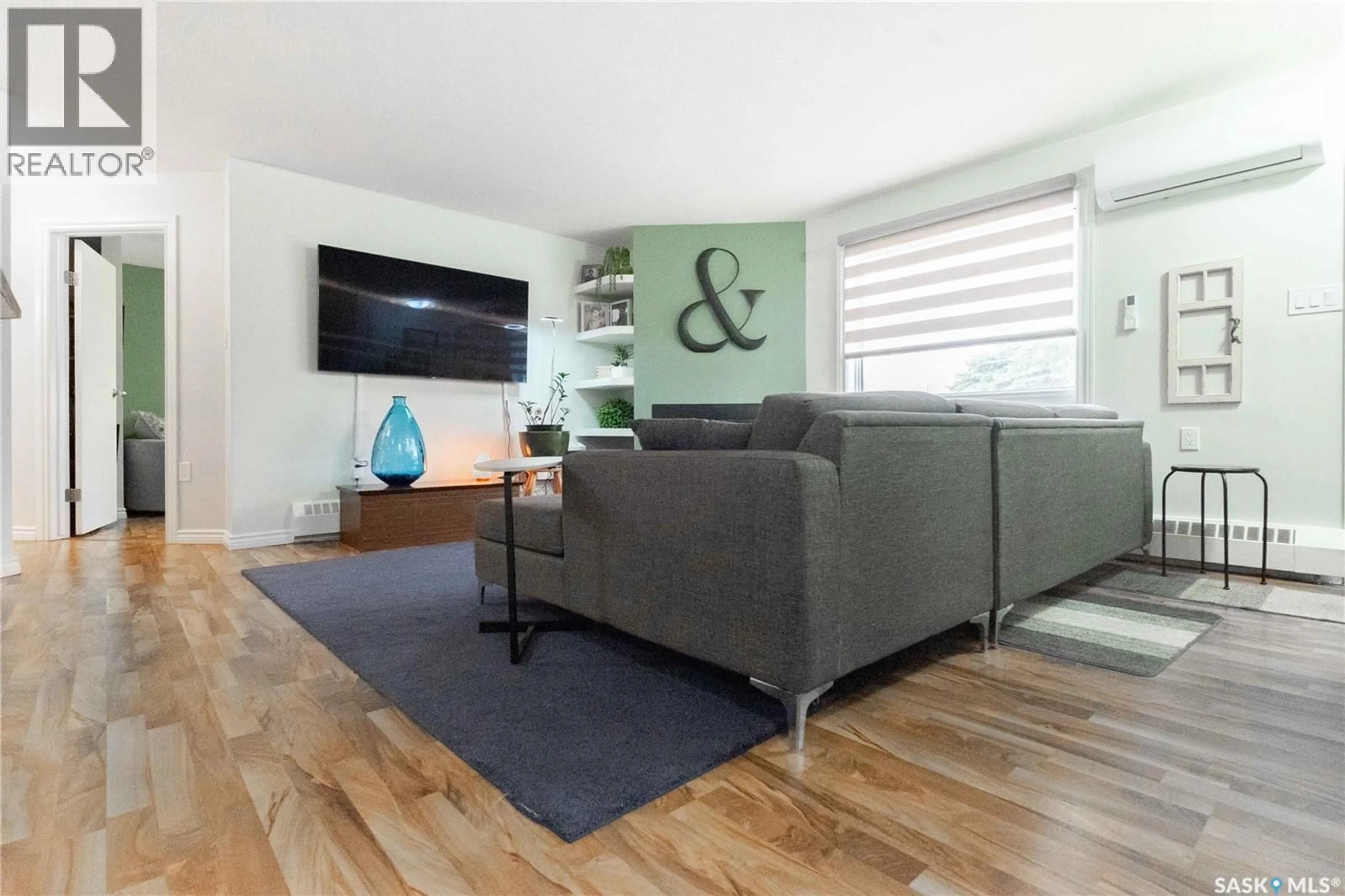 Living room with furniture, wood/laminate floor for 202 - 2911 HARDING STREET, Regina Saskatchewan S4V1B9