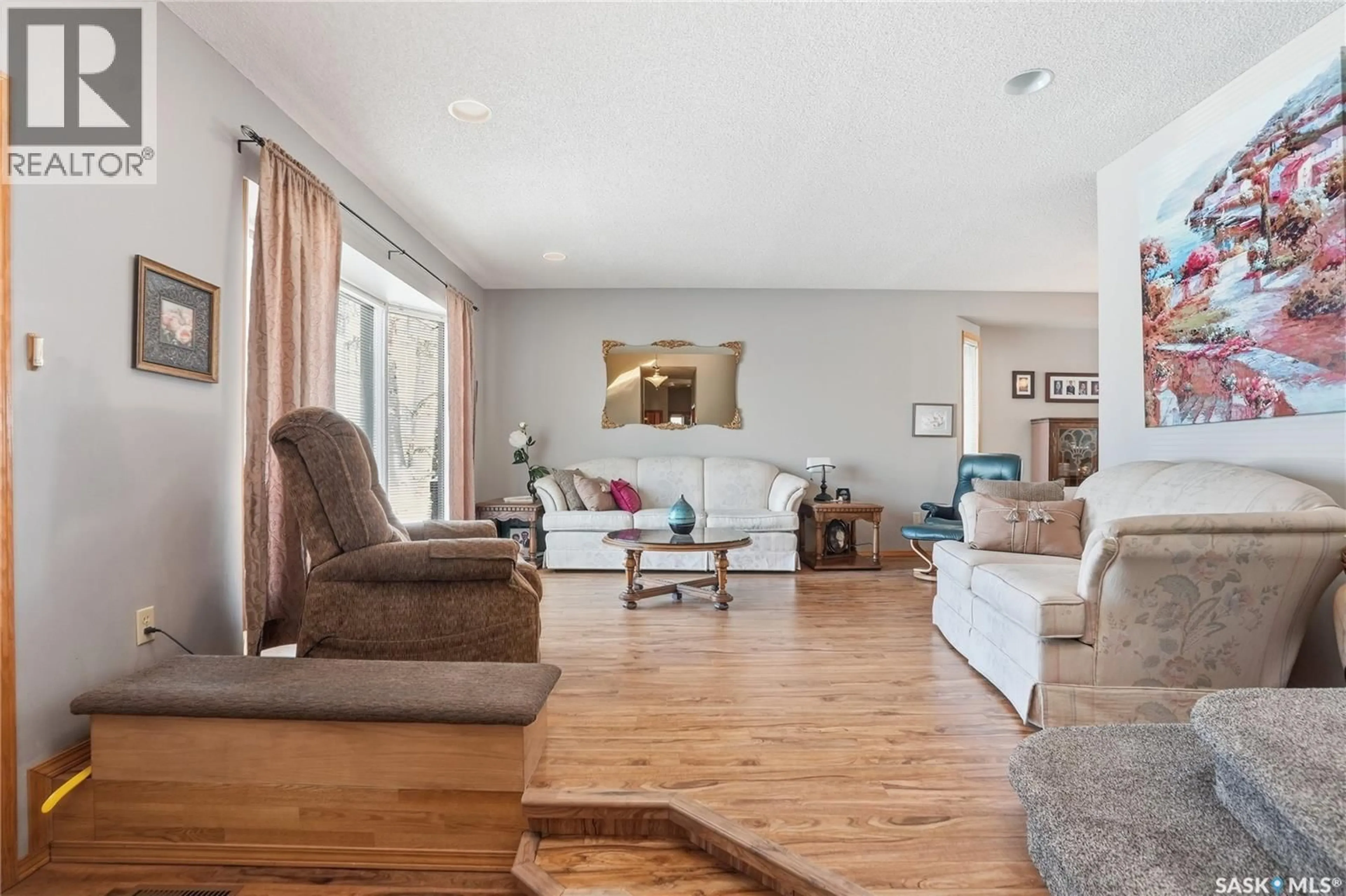 Living room with furniture, wood/laminate floor for 647 WHITESWAN DRIVE, Saskatoon Saskatchewan S7K8A2