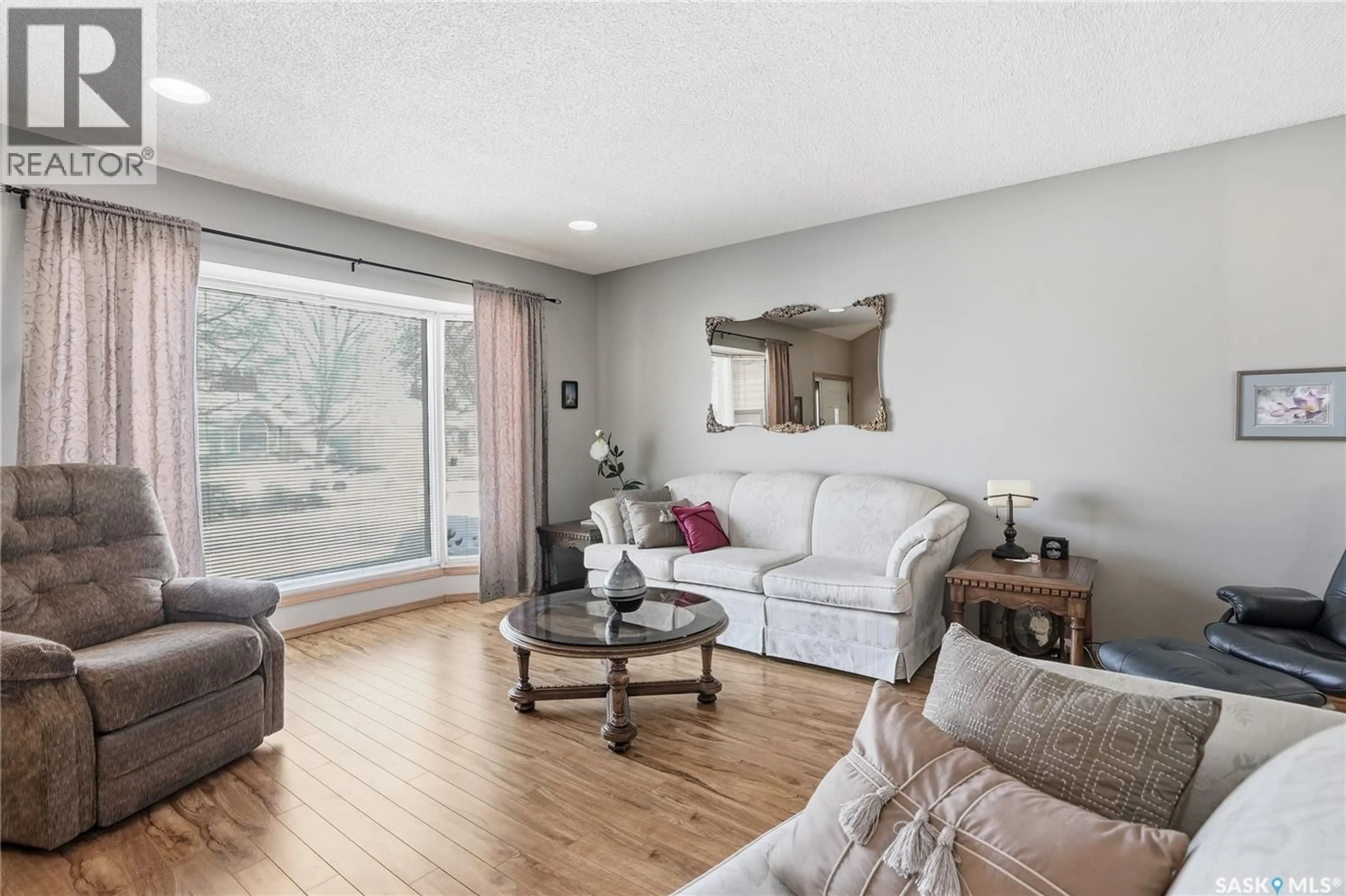 Living room with furniture, wood/laminate floor for 647 WHITESWAN DRIVE, Saskatoon Saskatchewan S7K8A2