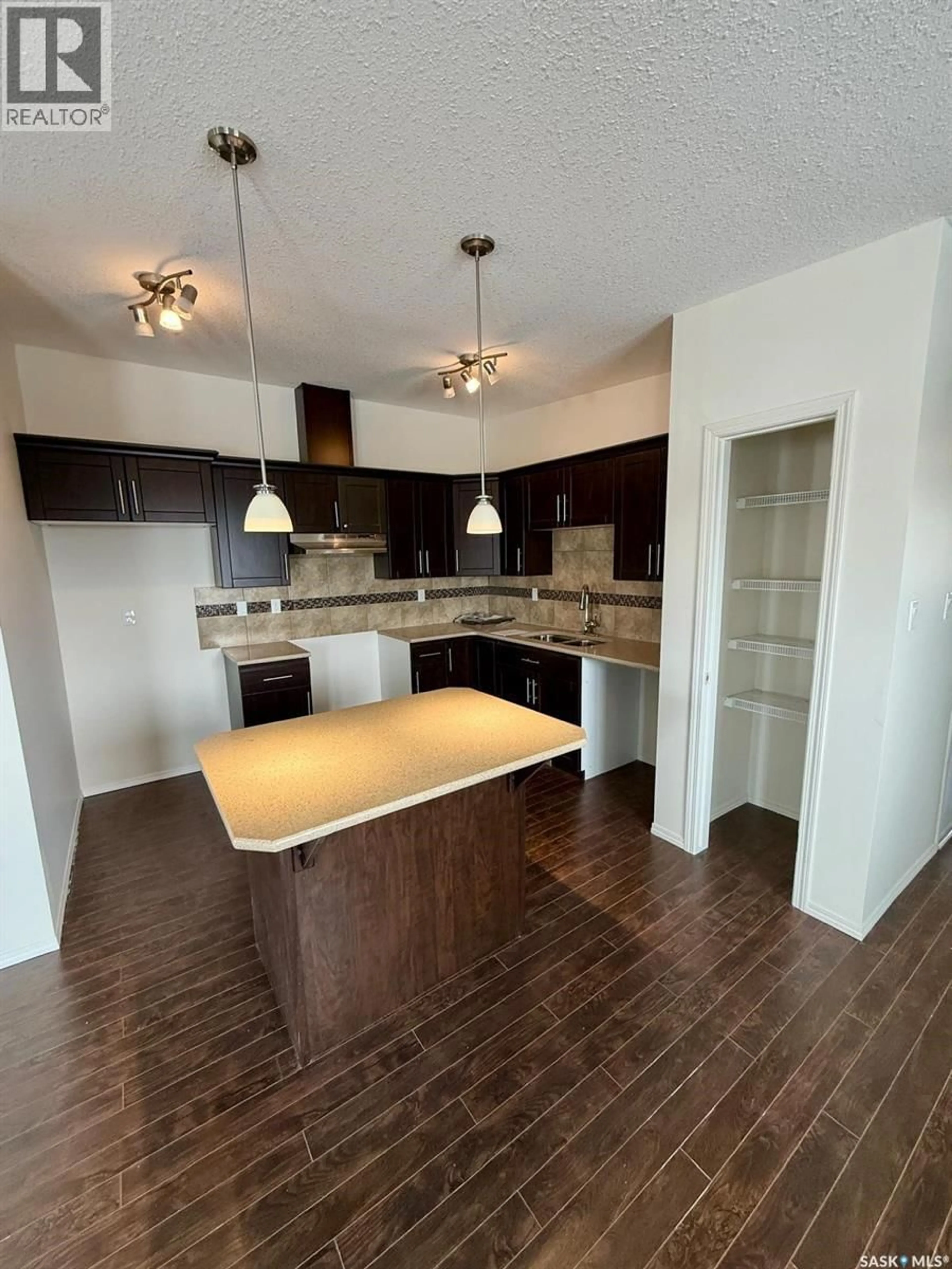 Open concept kitchen, wood/laminate floor for 179 CHATEAU CRESCENT, Pilot Butte Saskatchewan S0G3Z0