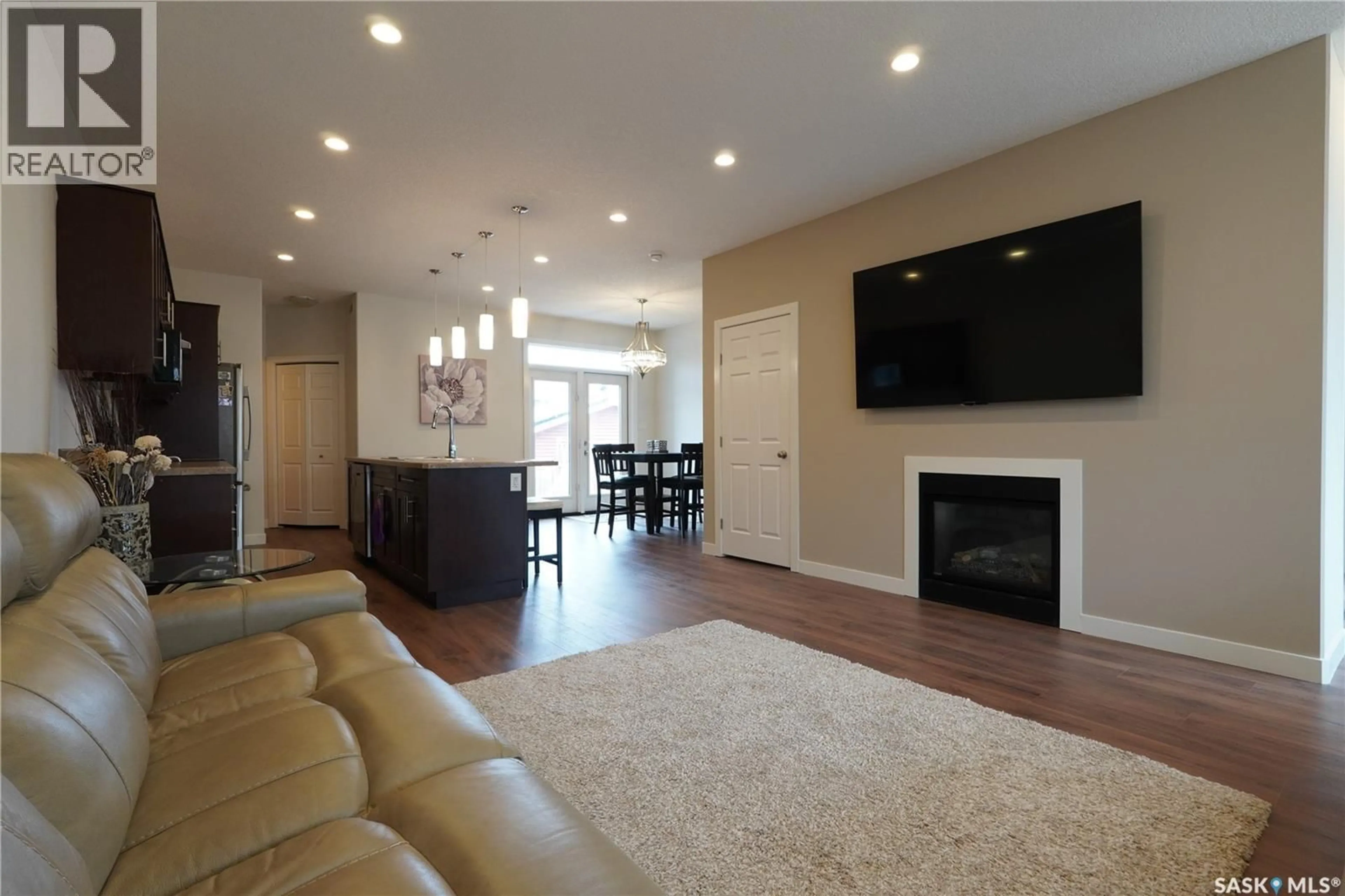 Living room with furniture, wood/laminate floor for E - 4125 GREEN OLIVE WAY, Regina Saskatchewan S4V1P8