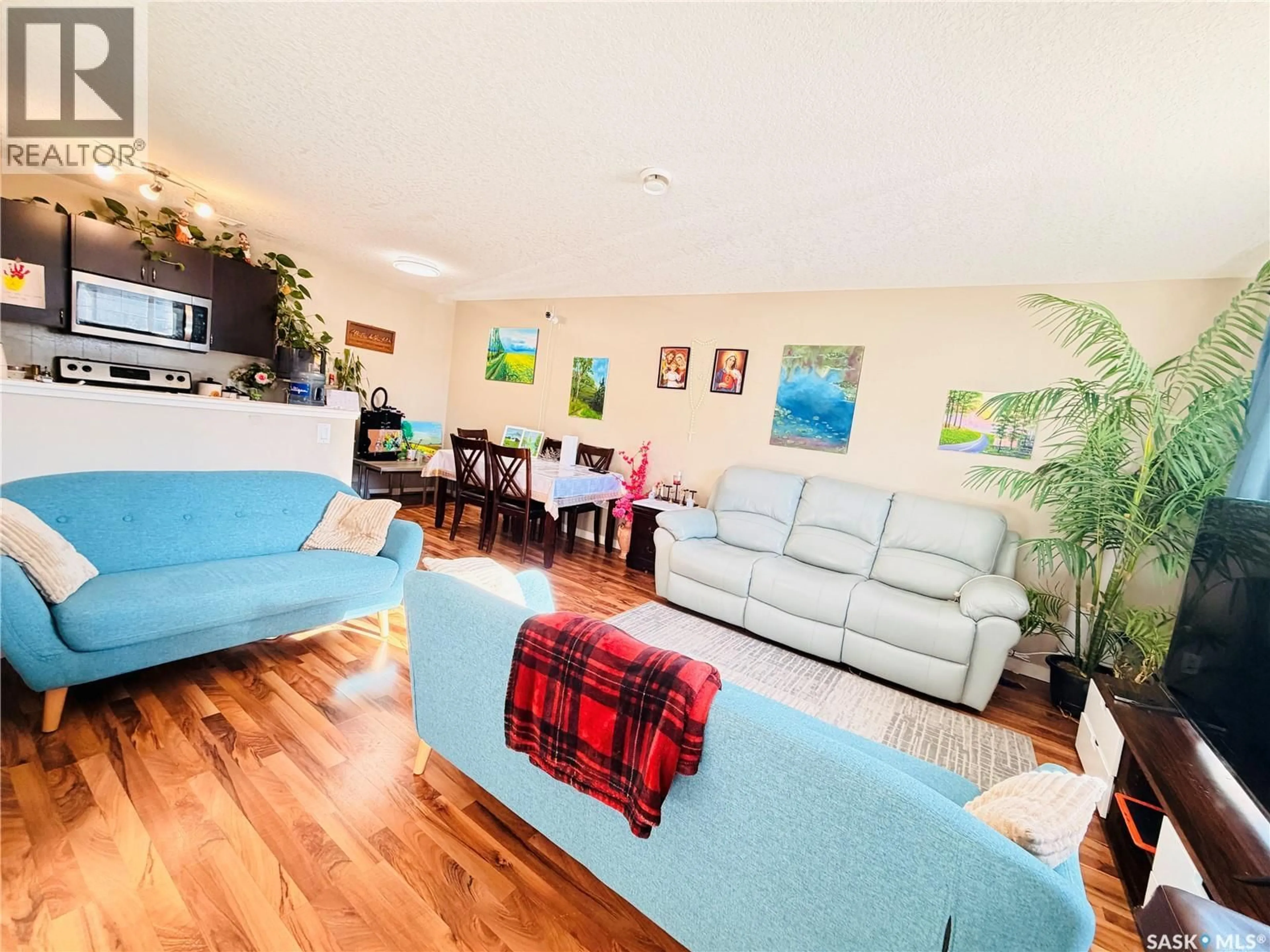 Living room with furniture, wood/laminate floor for 105 - 5051 JAMES HILL ROAD, Regina Saskatchewan S4W0B9