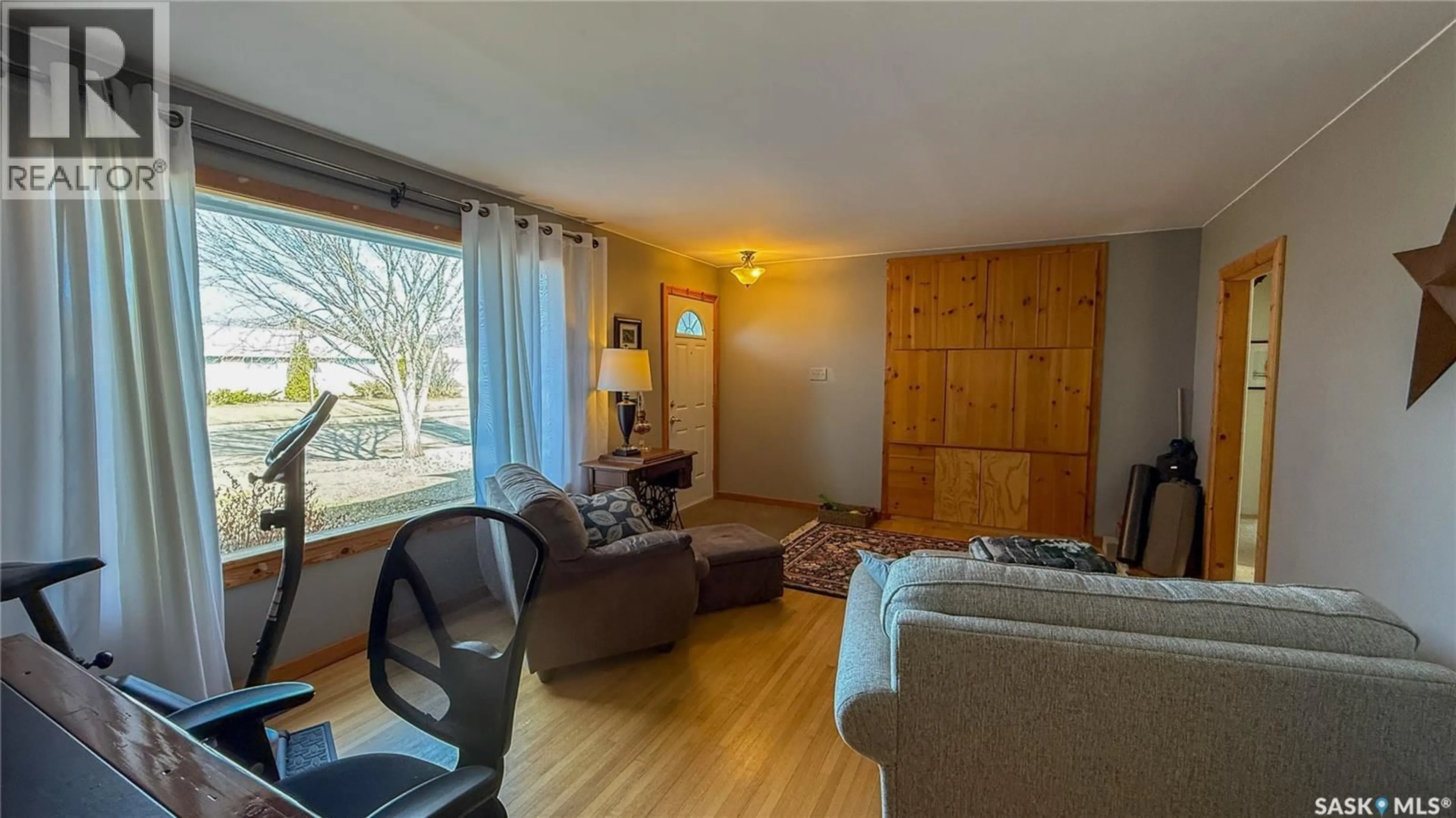 Living room with furniture, wood/laminate floor for 1752 93RD STREET, North Battleford Saskatchewan S9A0C8