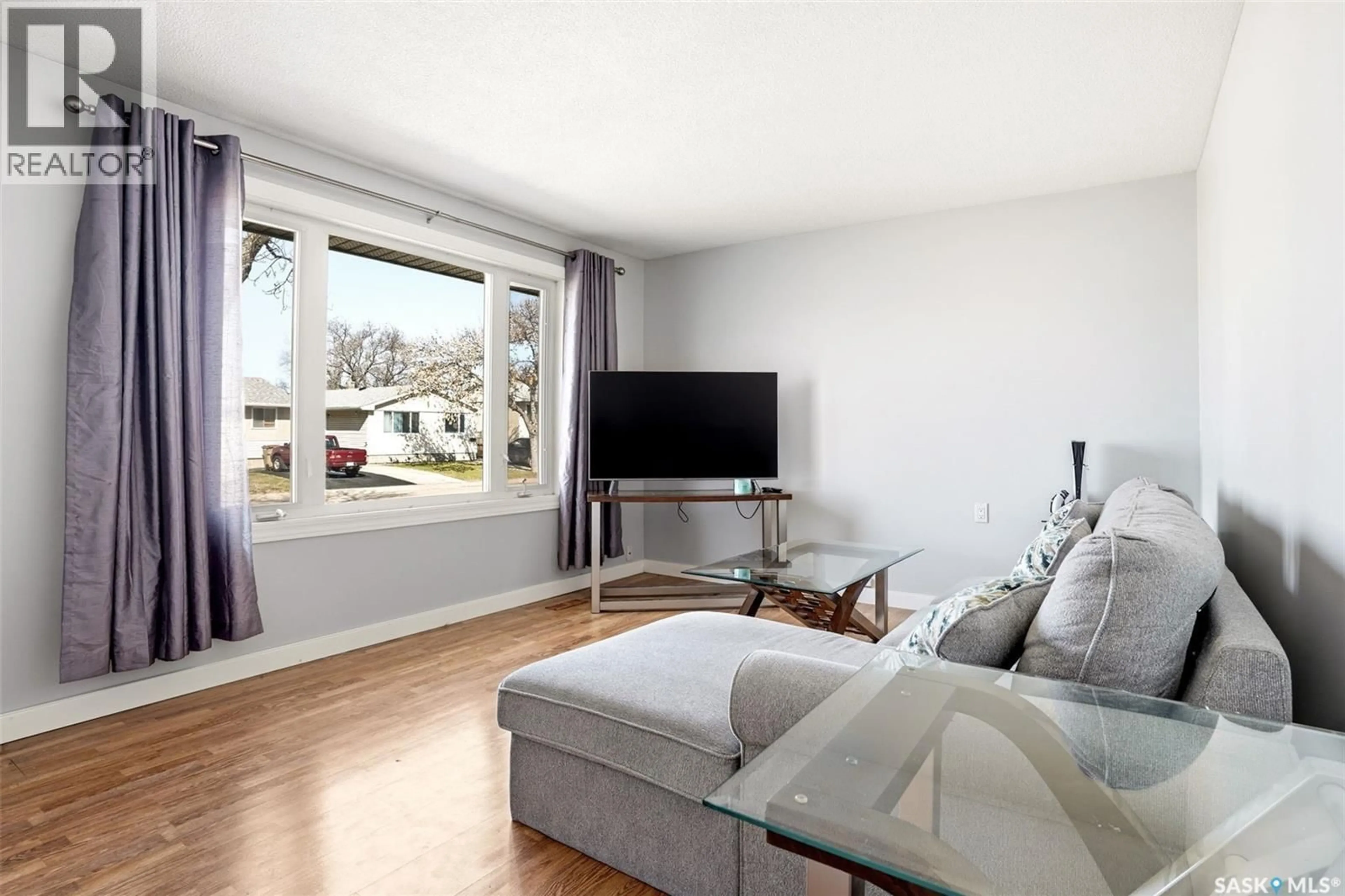 Living room with furniture, wood/laminate floor for 87 CARMICHAEL ROAD, Regina Saskatchewan S4R0C6