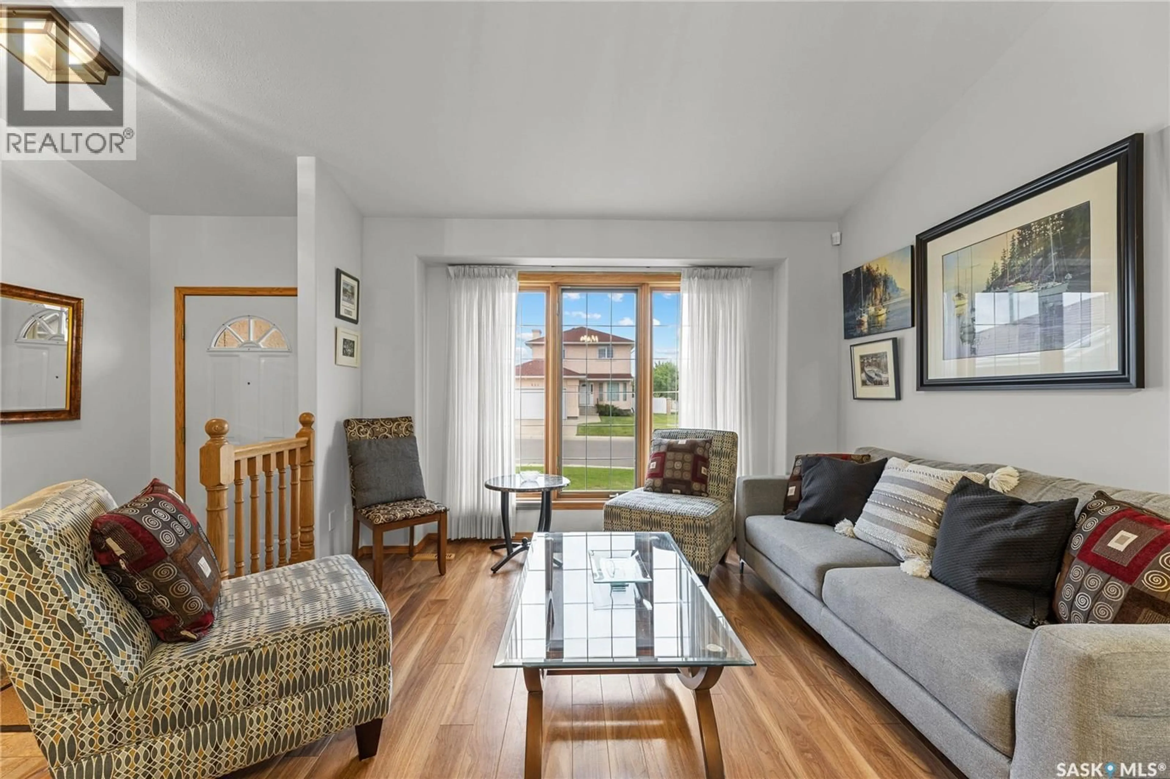 Living room with furniture, wood/laminate floor for 619 BLACKSHIRE CRESCENT, Saskatoon Saskatchewan S7V1B4