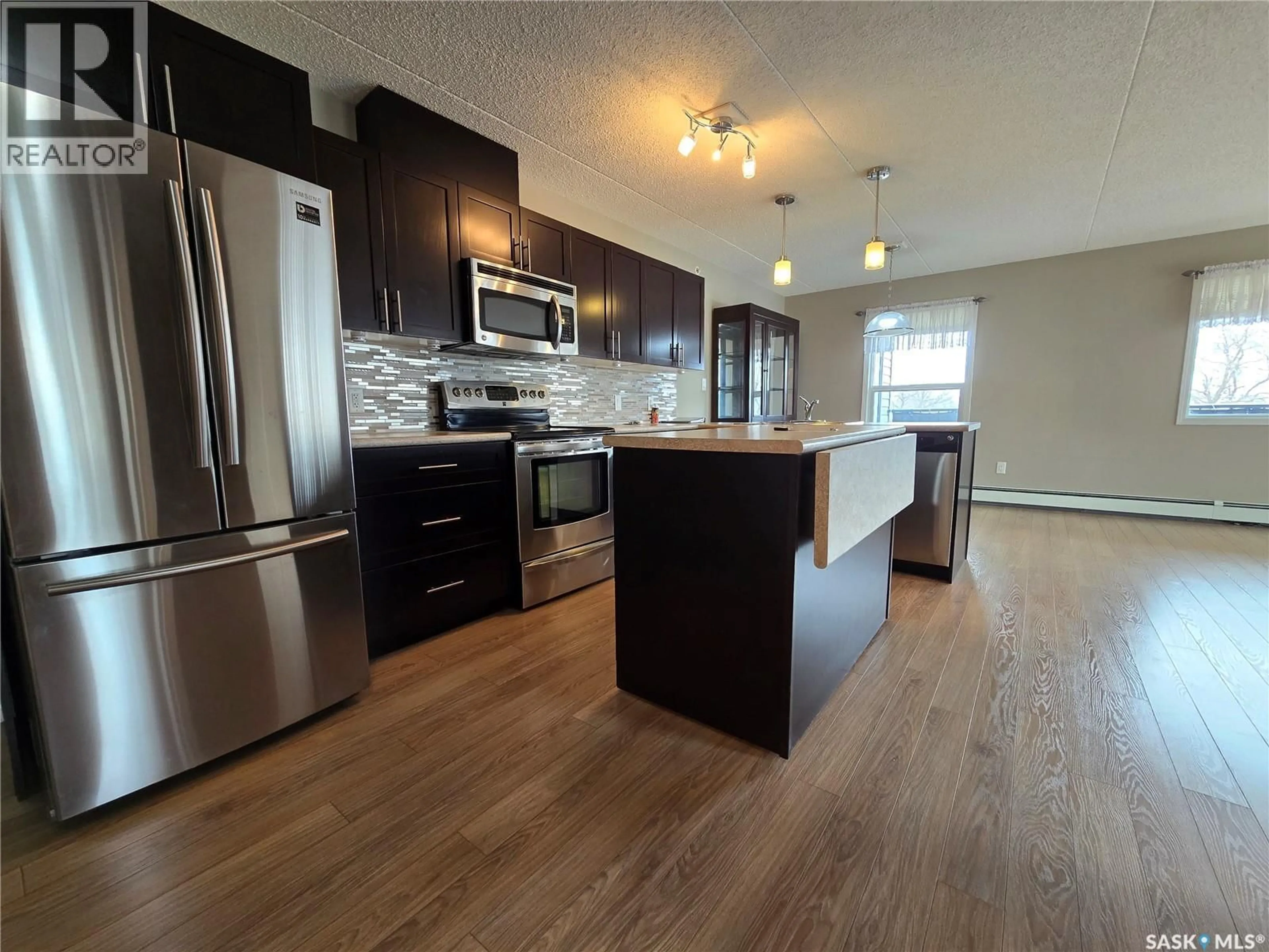 Open concept kitchen, wood/laminate floor for 208 - 505 BANNERMAN STREET, Weyburn Saskatchewan S4H1V5