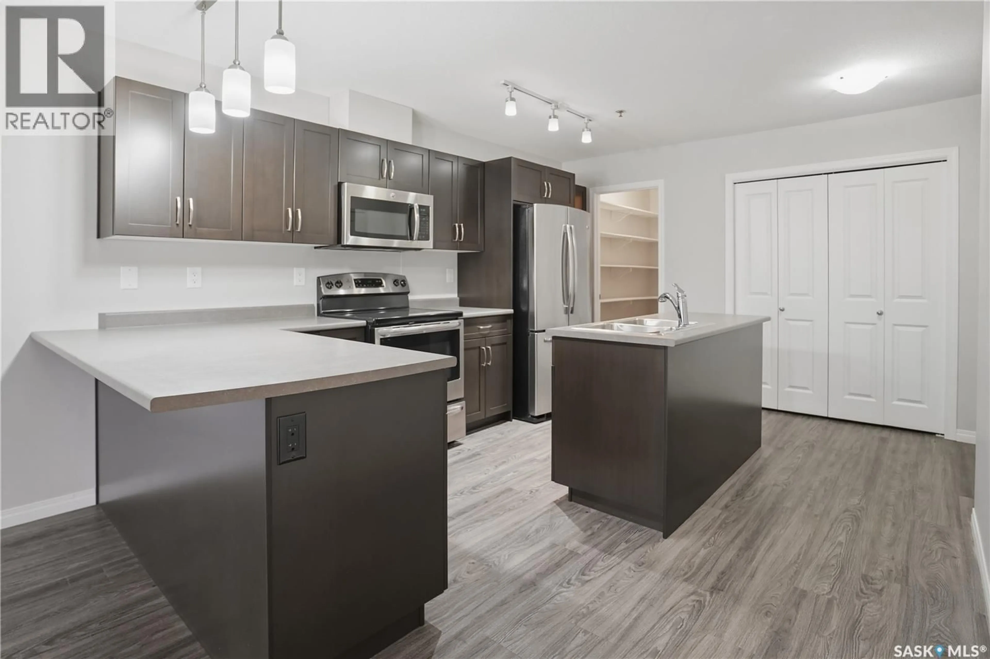 Open concept kitchen, wood/laminate floor for 201 - 2452 KILLDEER DRIVE, North Battleford Saskatchewan S9A3T5