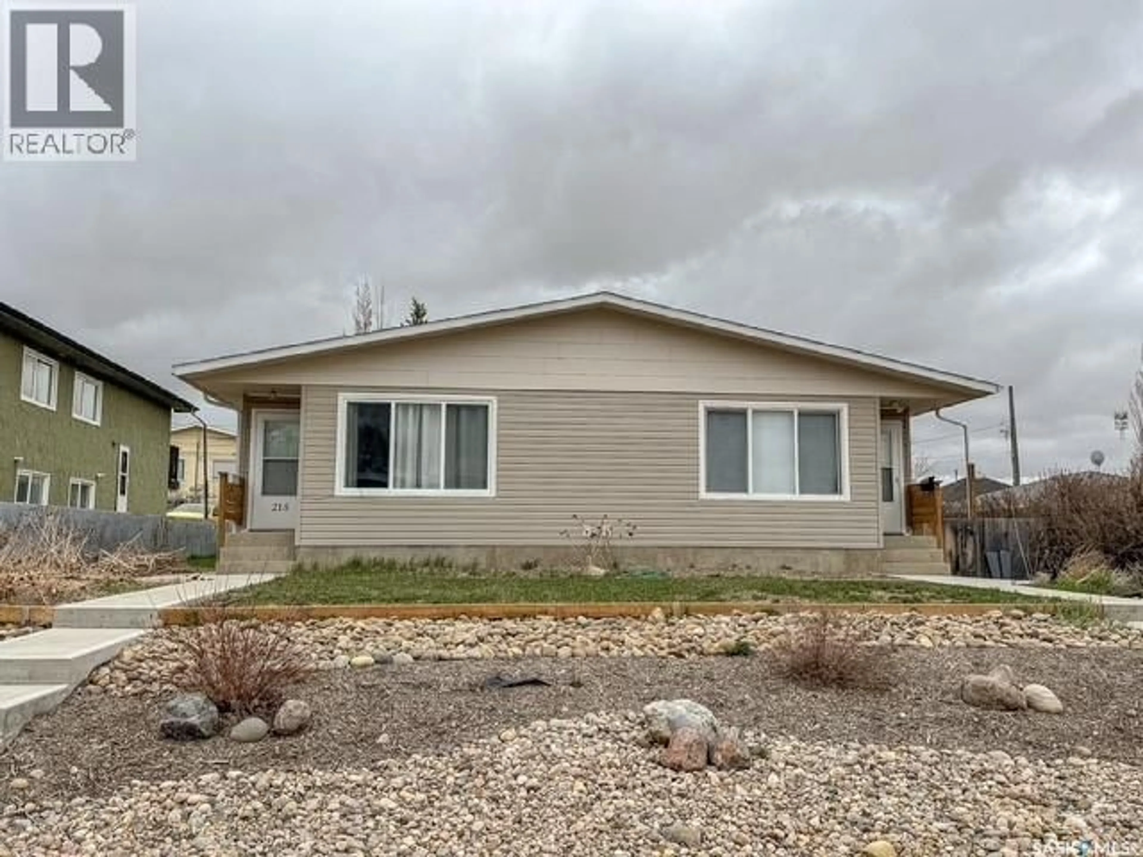 Home with vinyl exterior material, street for 211 & 215 18TH AVENUE, Swift Current Saskatchewan S9H2Y2