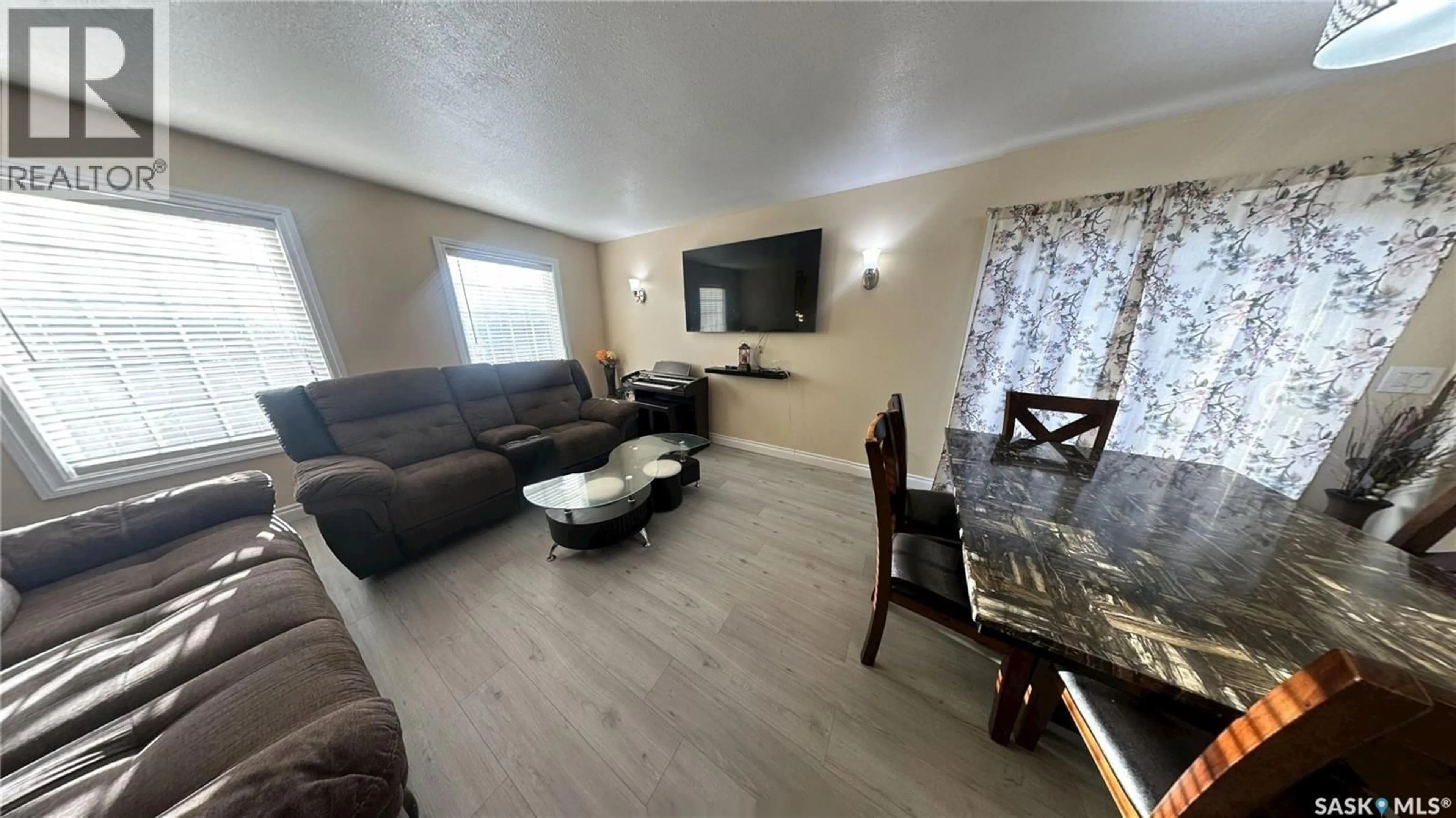 Living room with furniture, wood/laminate floor for 415 COAD MANOR, Saskatoon Saskatchewan S7R0C6