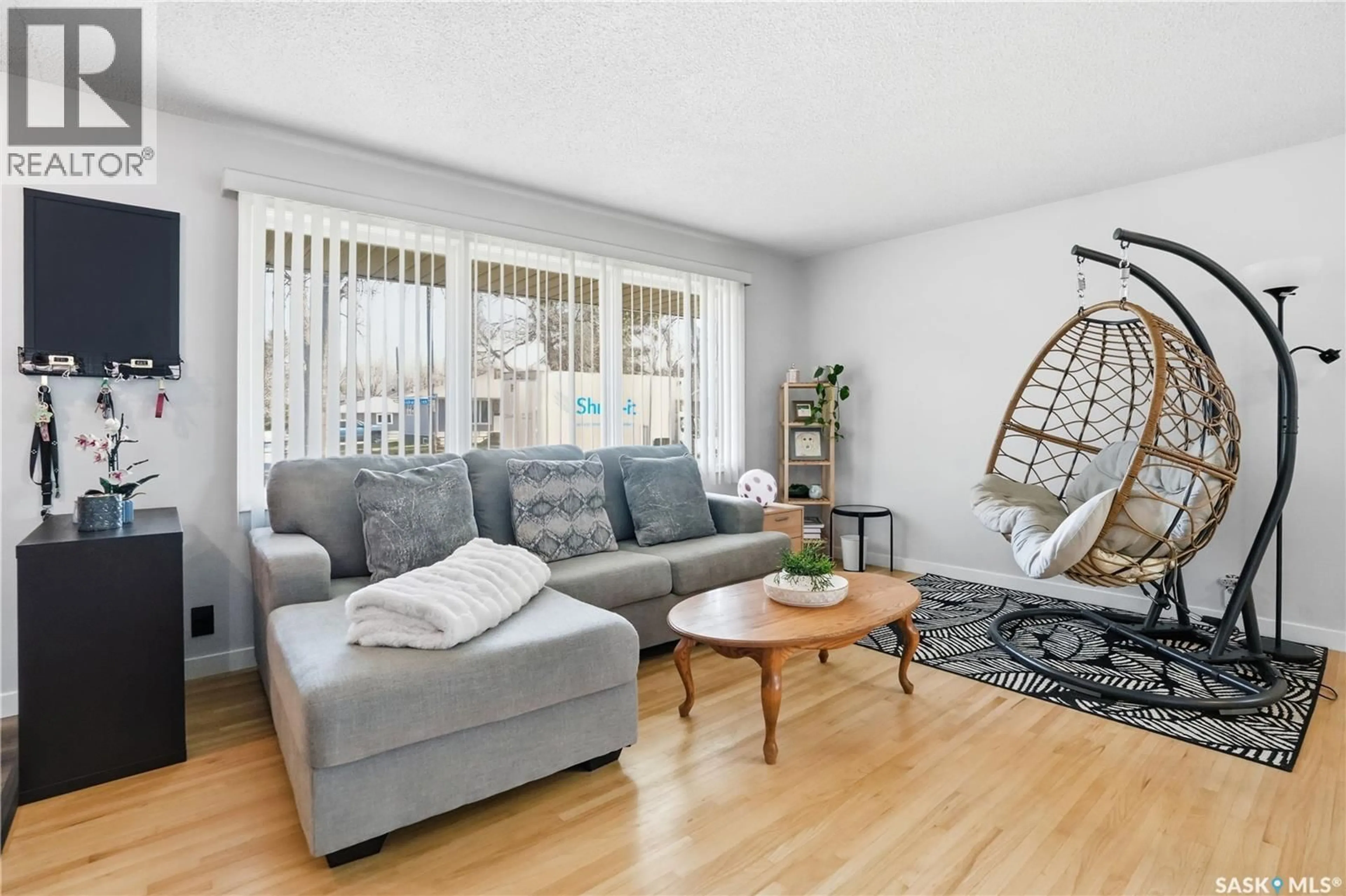 Living room with furniture, wood/laminate floor for 245 ORCHARD CRESCENT, Regina Saskatchewan S4S5B9