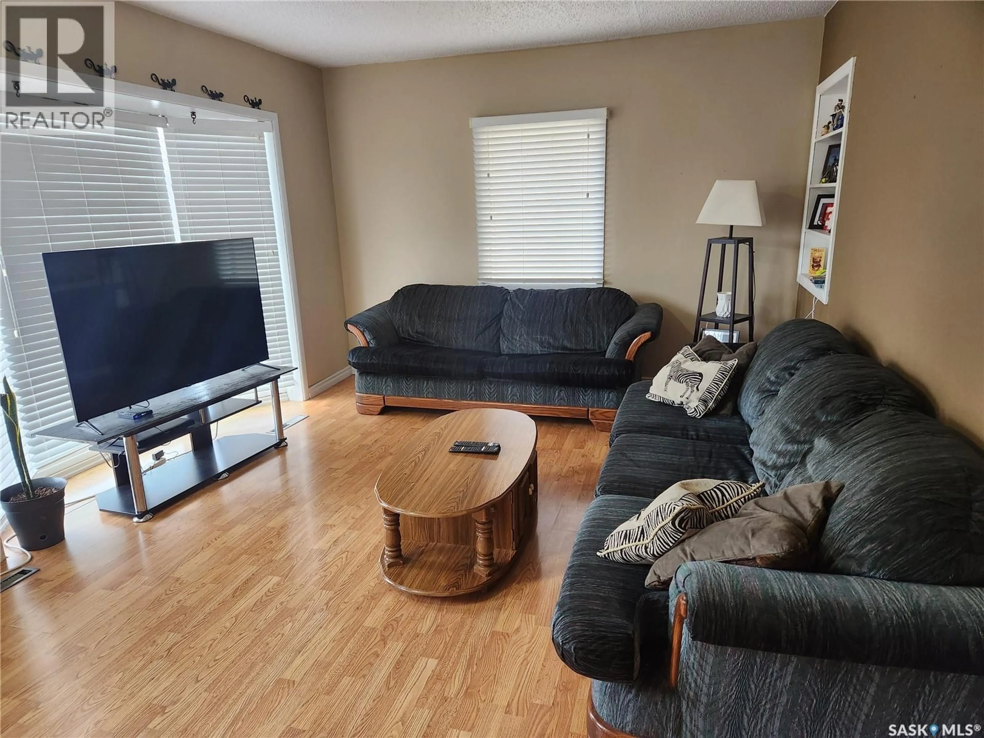 Living room with furniture, wood/laminate floor for 1018 108TH AVENUE, Tisdale Saskatchewan S0E1T0