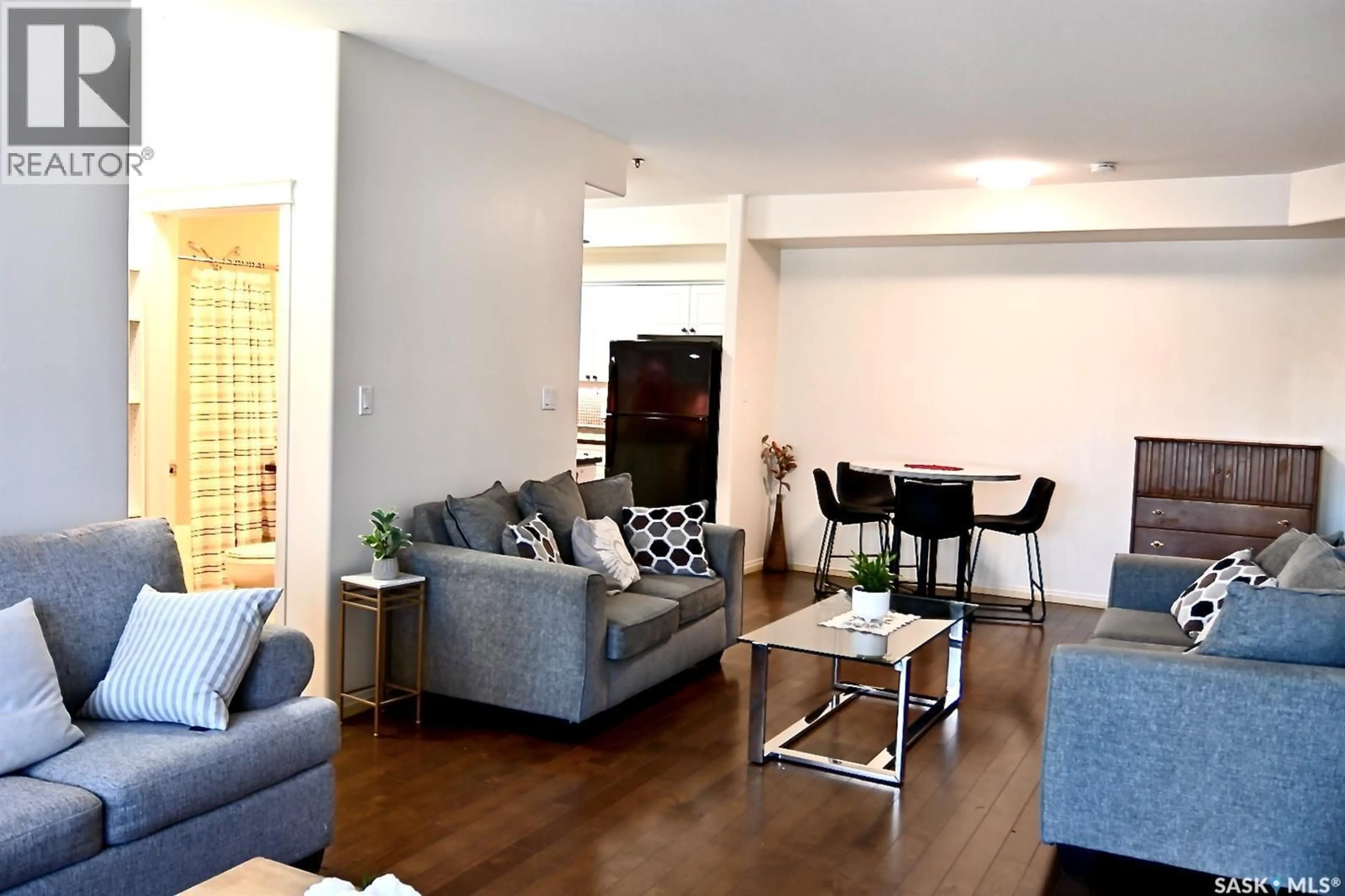 Living room with furniture, wood/laminate floor for 106 110 ARMISTICE WAY, Saskatoon Saskatchewan S7J5L8