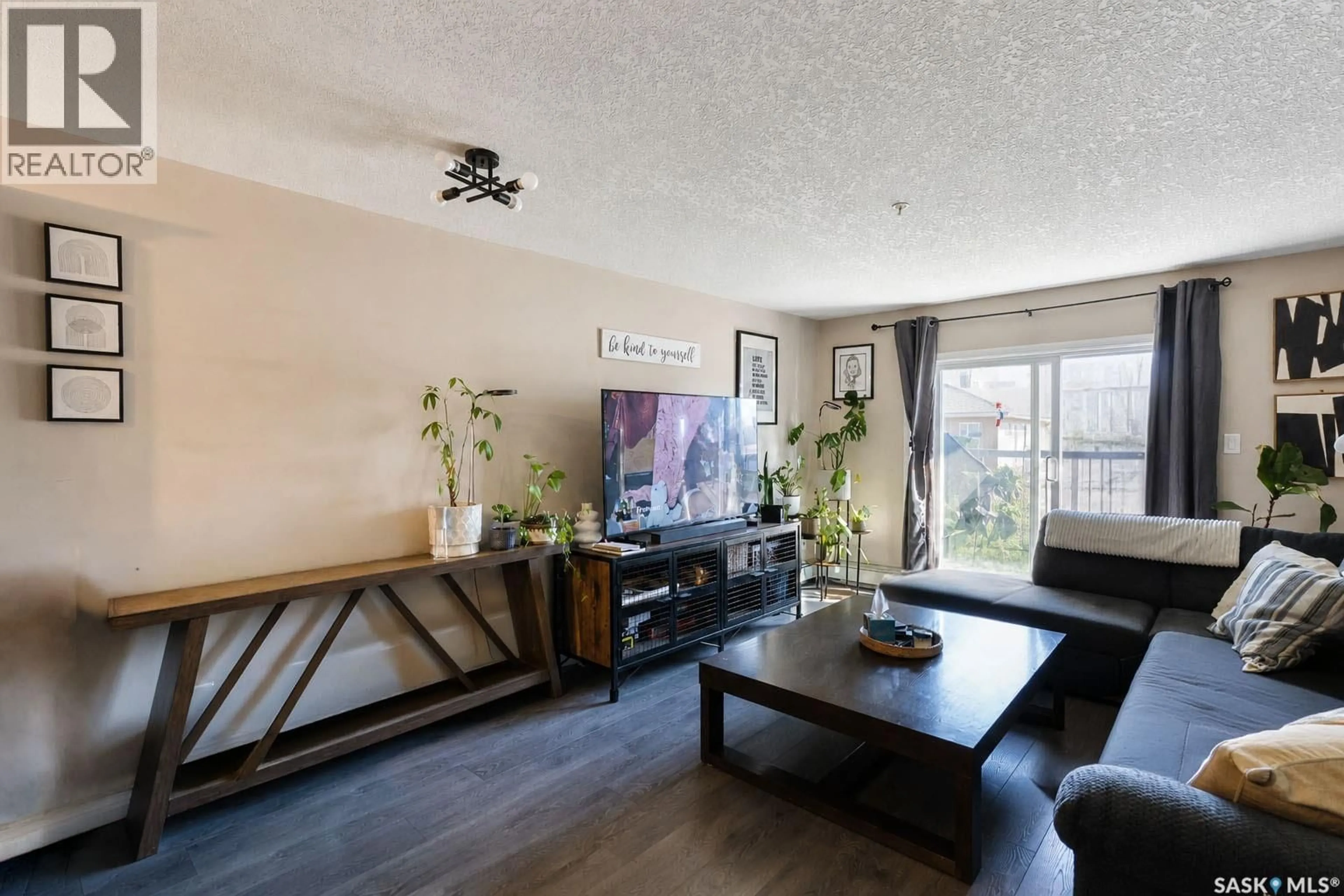 Living room with furniture, wood/laminate floor for 102 - 1501 15TH STREET, Prince Albert Saskatchewan S6V7C3