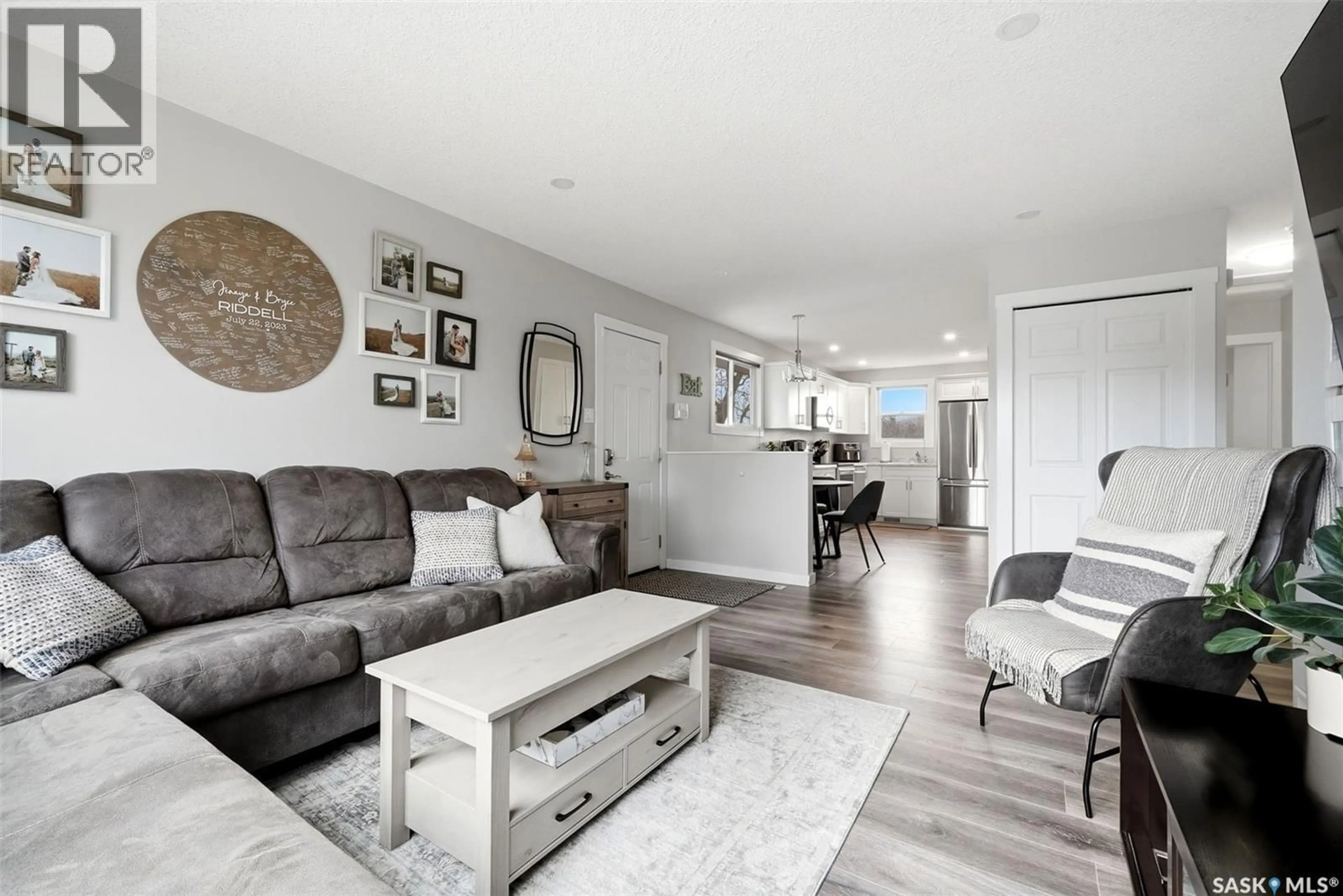 Living room with furniture, wood/laminate floor for 68 CARMICHAEL ROAD, Regina Saskatchewan S4R0C5