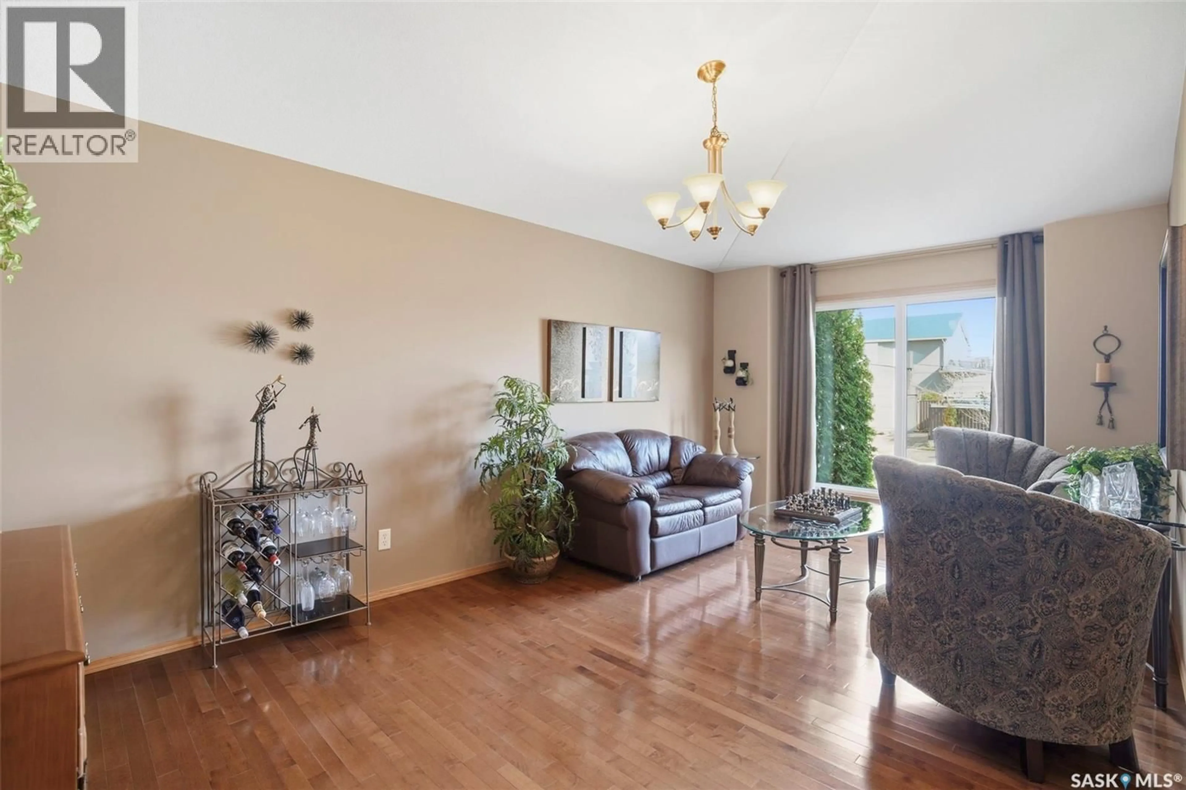 Living room with furniture, wood/laminate floor for 211 BROOKMORE LANE, Saskatoon Saskatchewan S7V1C1