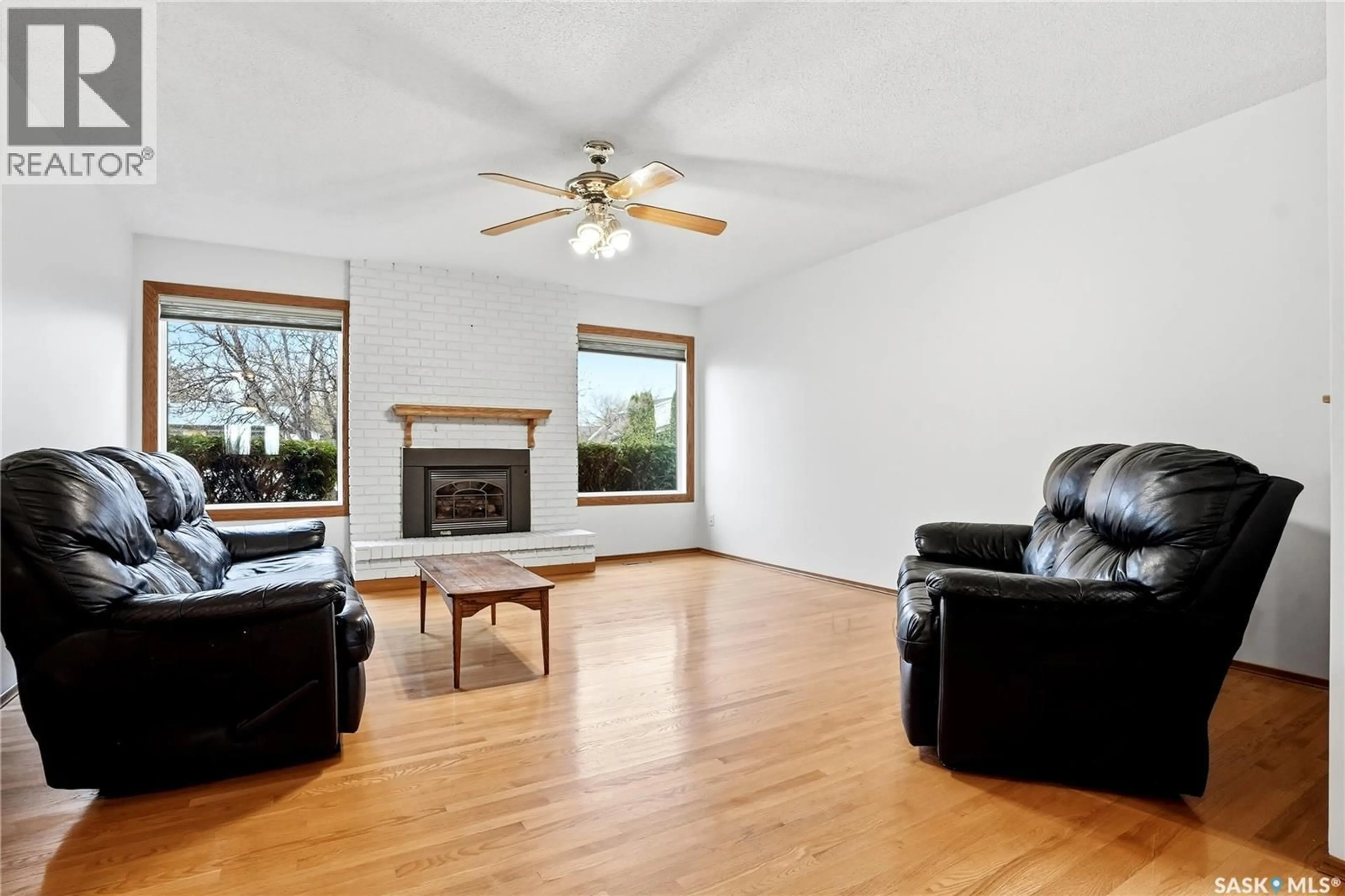 Living room with furniture, wood/laminate floor for 155 J.J. THIESSEN CRESCENT, Saskatoon Saskatchewan S7K5N9