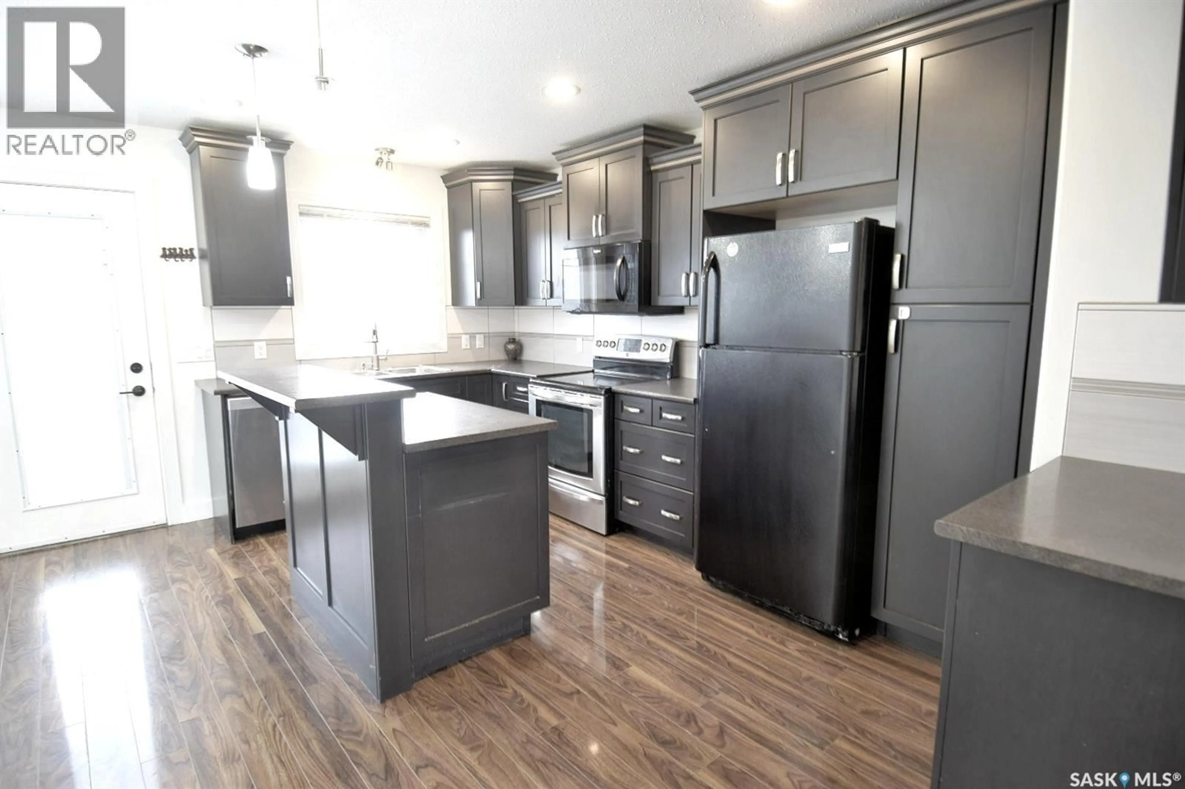 Open concept kitchen, wood/laminate floor for 242 GEARY CRESCENT, Saskatoon Saskatchewan S7R0E6