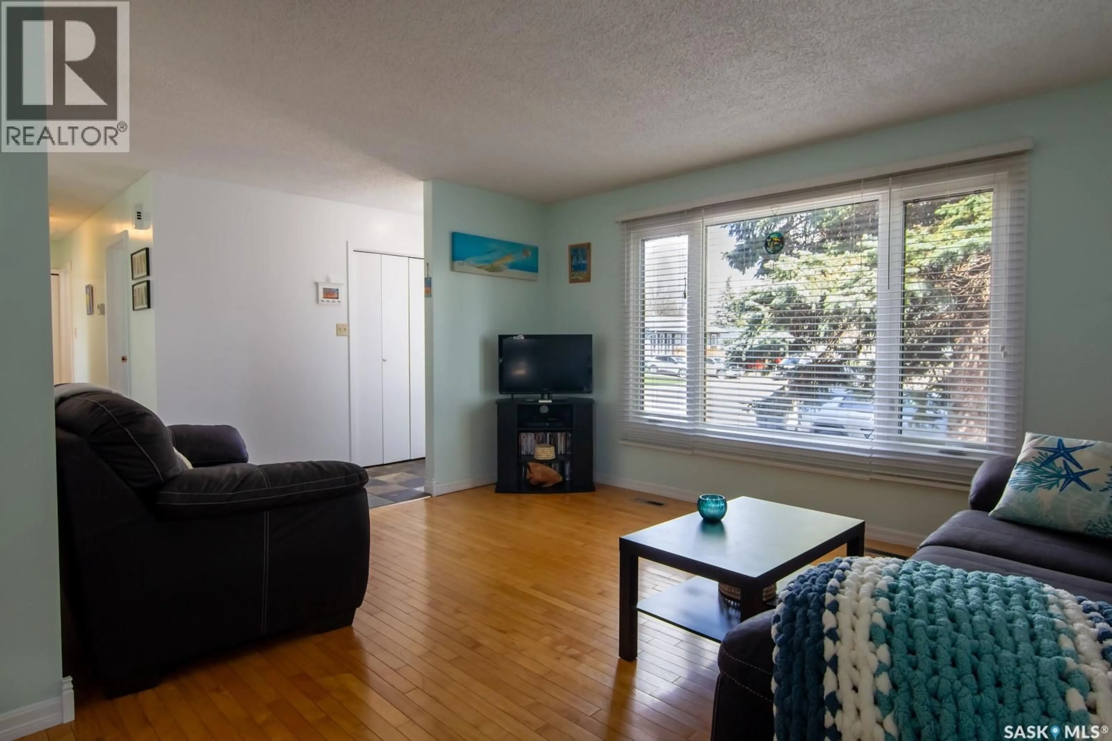 Living room with furniture, wood/laminate floor for 127 DEVONSHIRE CRESCENT, Saskatoon Saskatchewan S7L5V6