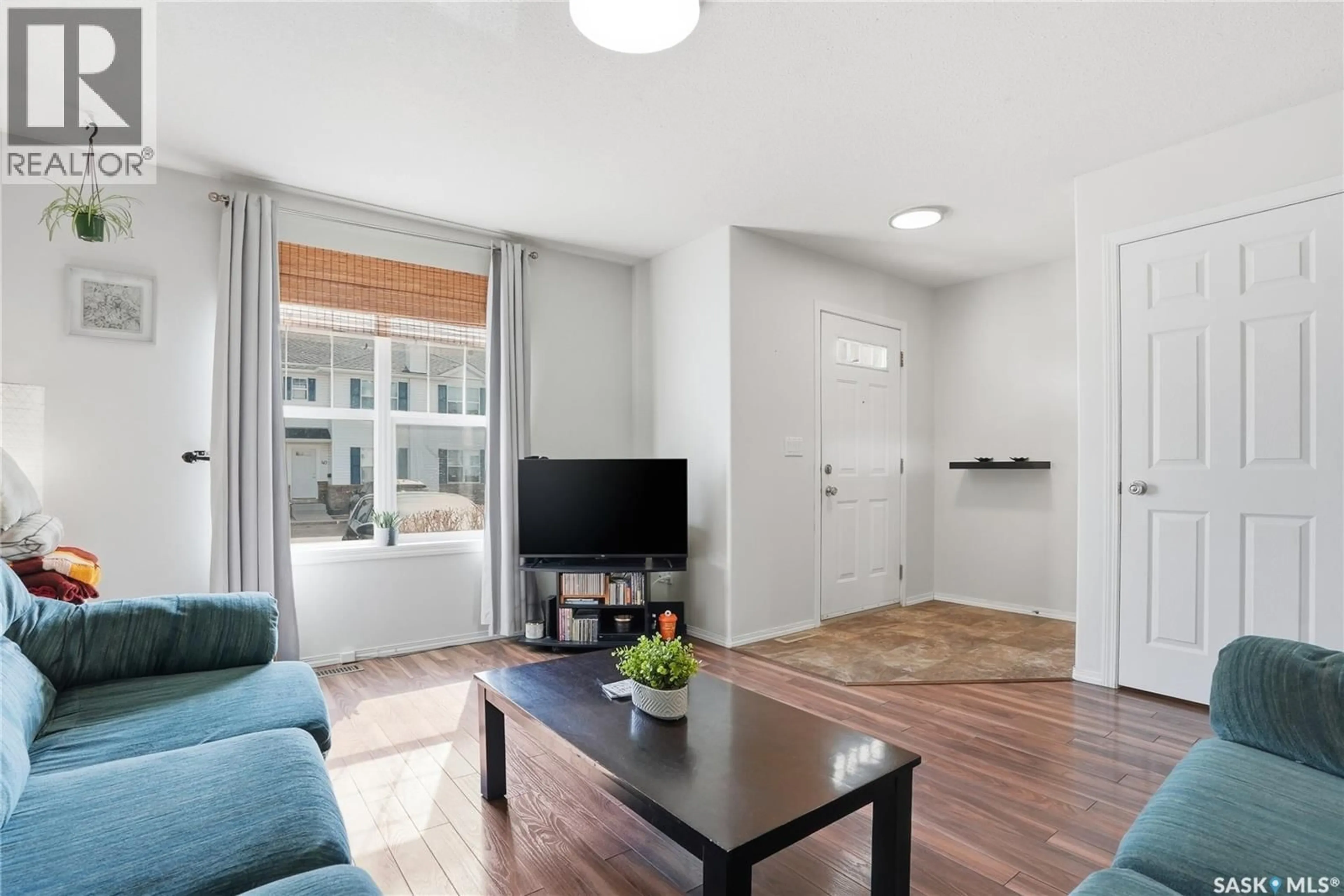 Living room with furniture, wood/laminate floor for 49 203 HEROLD TERRACE, Saskatoon Saskatchewan S7V1H3