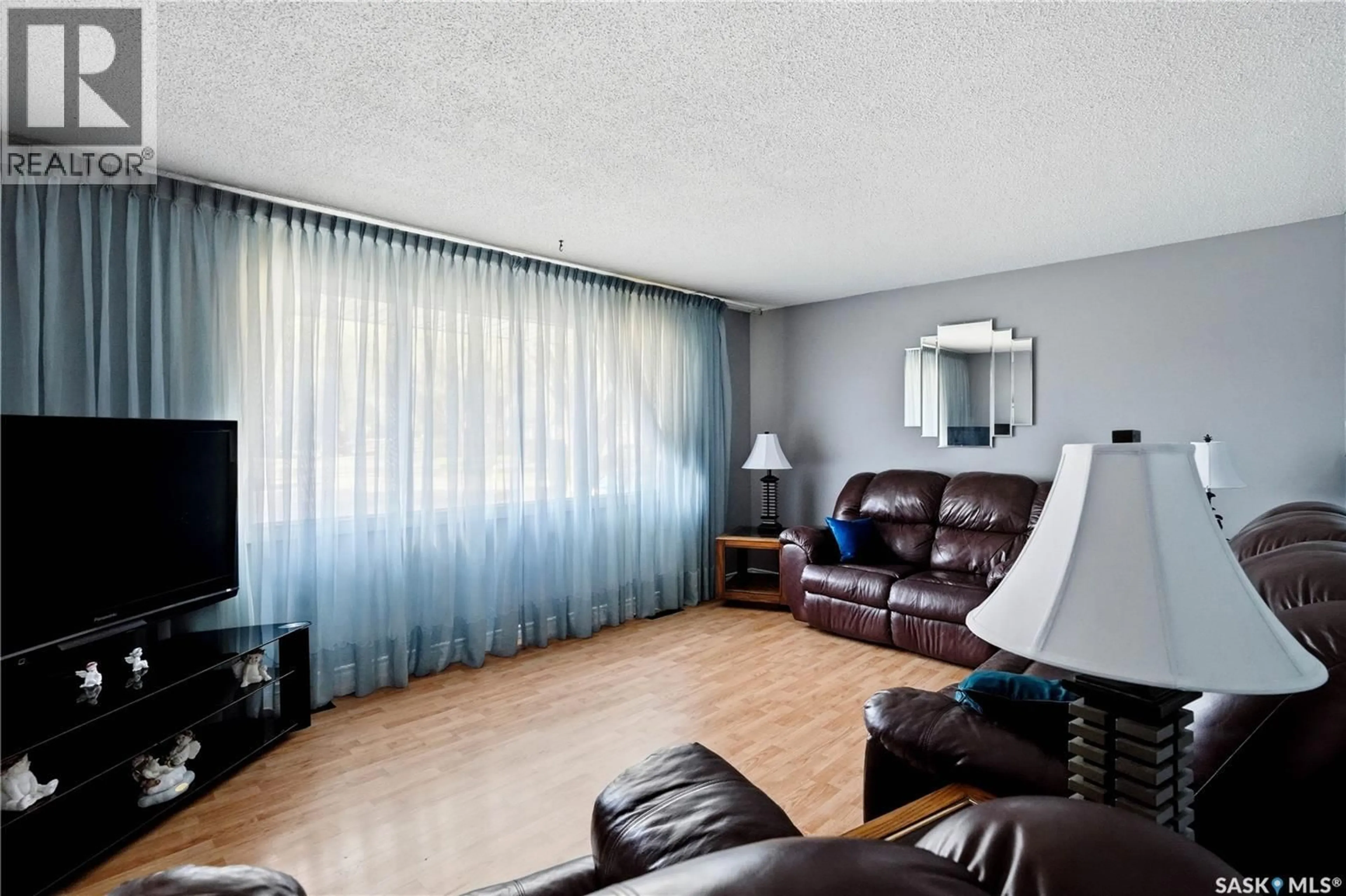Living room with furniture, wood/laminate floor for 35 MCINNIS CRESCENT, Regina Saskatchewan S4R3E7