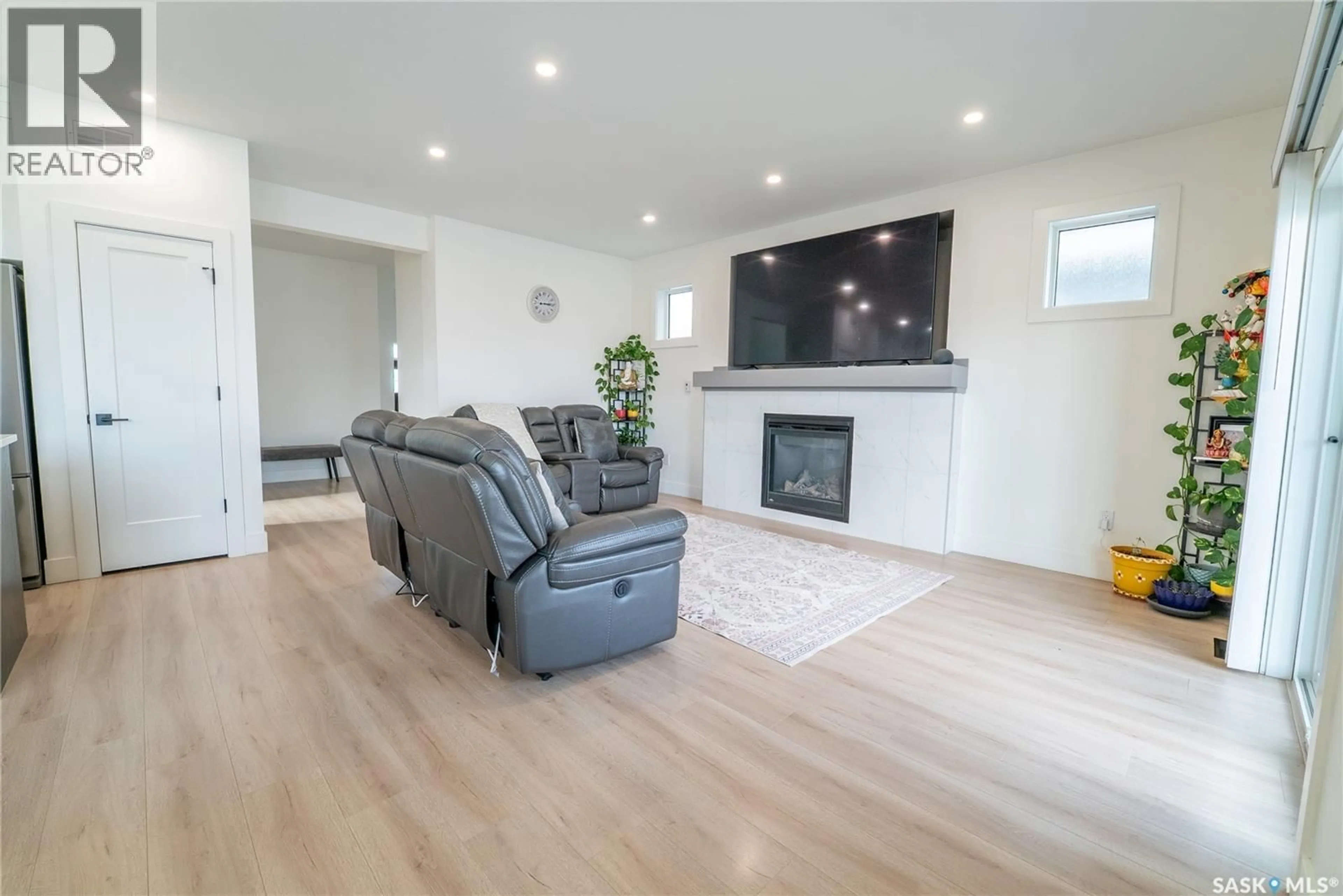 Living room with furniture, wood/laminate floor for 916 FEHEREGYHAZI BOULEVARD, Saskatoon Saskatchewan S7W1E1
