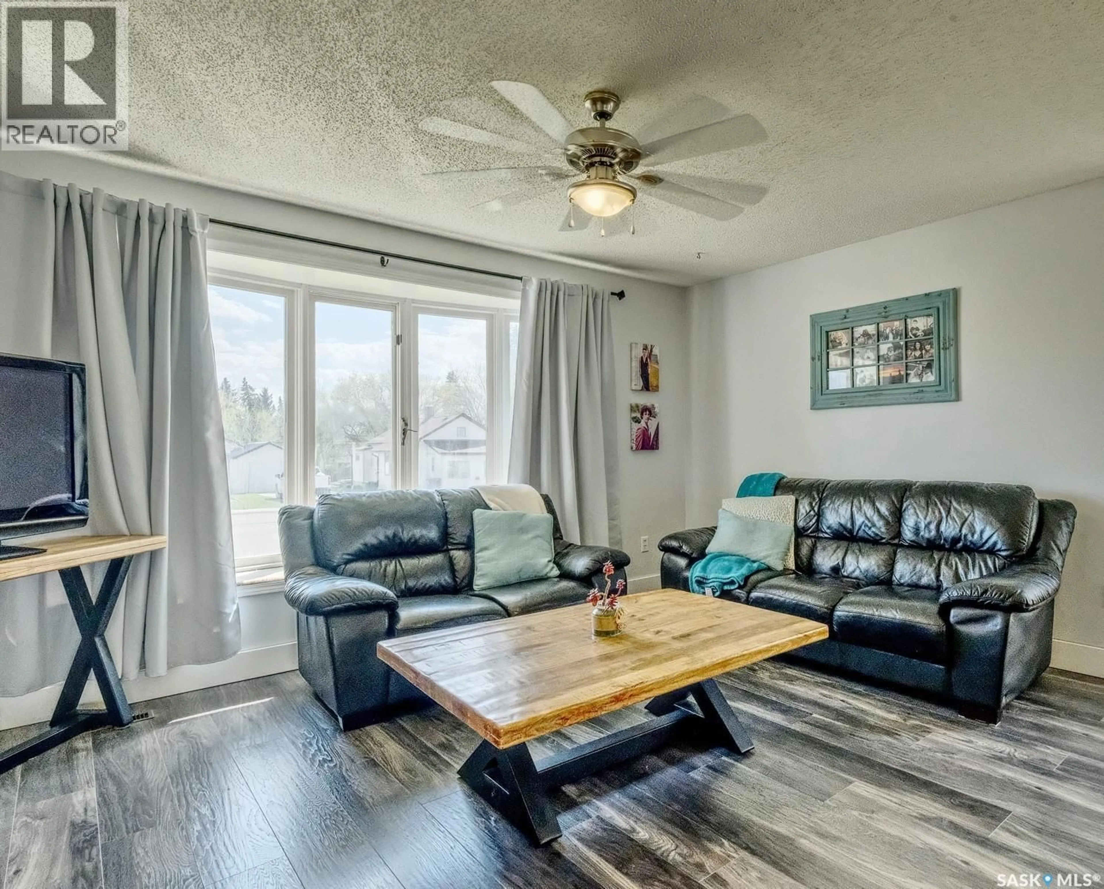 Living room with furniture, wood/laminate floor for 311 4TH AVENUE, Biggar Saskatchewan S0K0M0