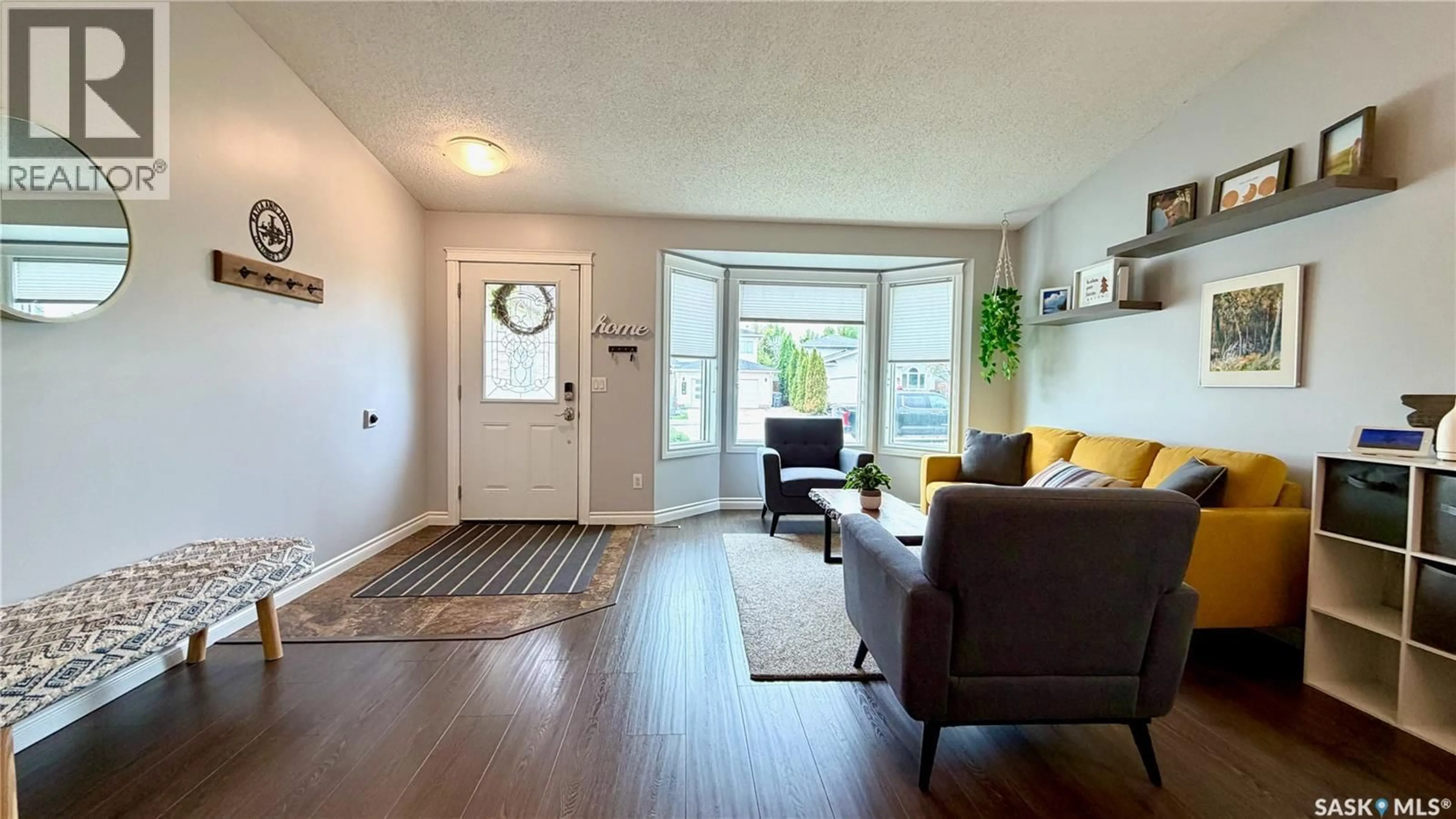 Living room with furniture, wood/laminate floor for 515 NEMEIBEN ROAD, Saskatoon Saskatchewan S7J5G6