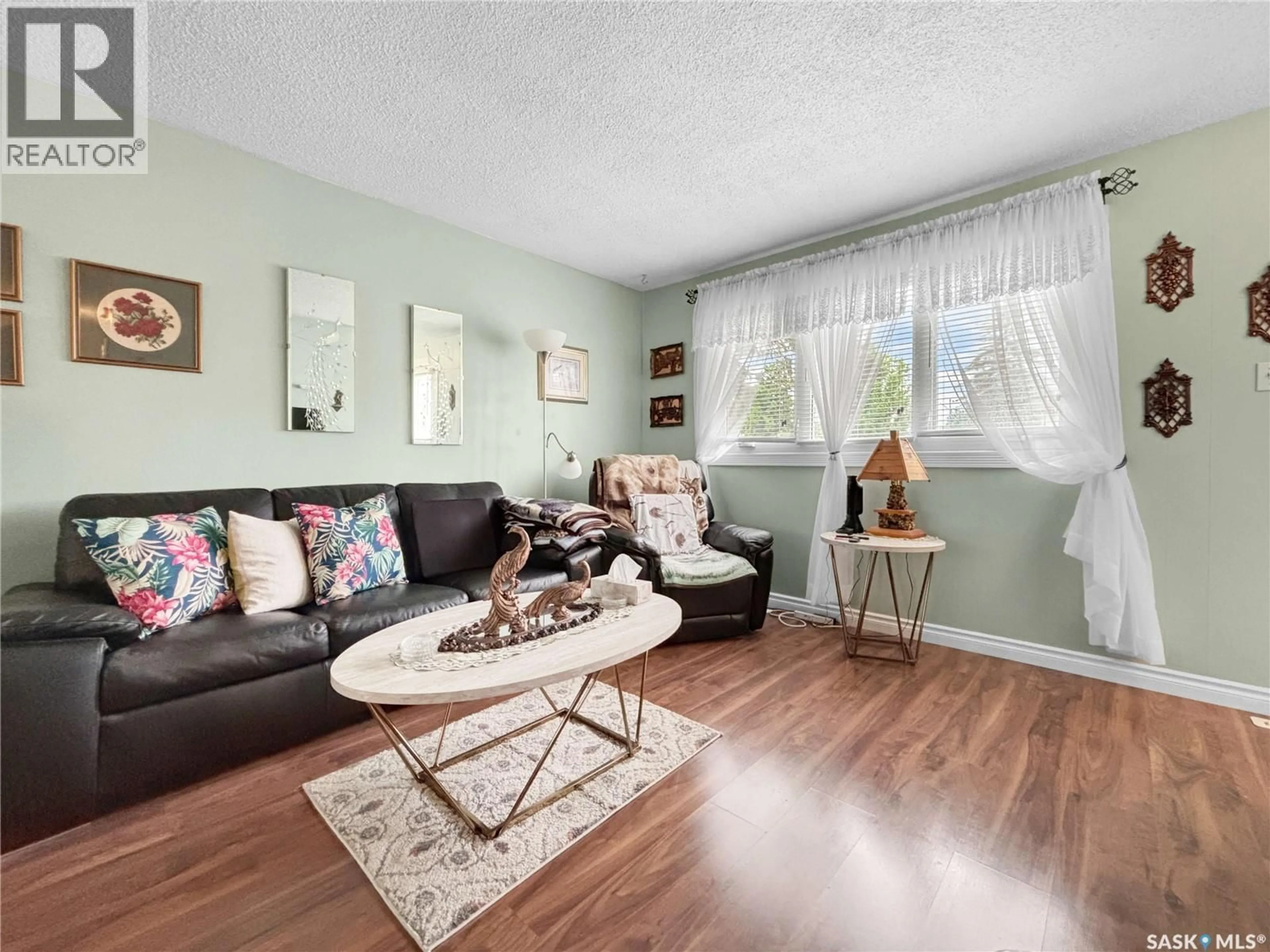 Living room with furniture, wood/laminate floor for 714 S AVENUE N, Saskatoon Saskatchewan S7L3A3