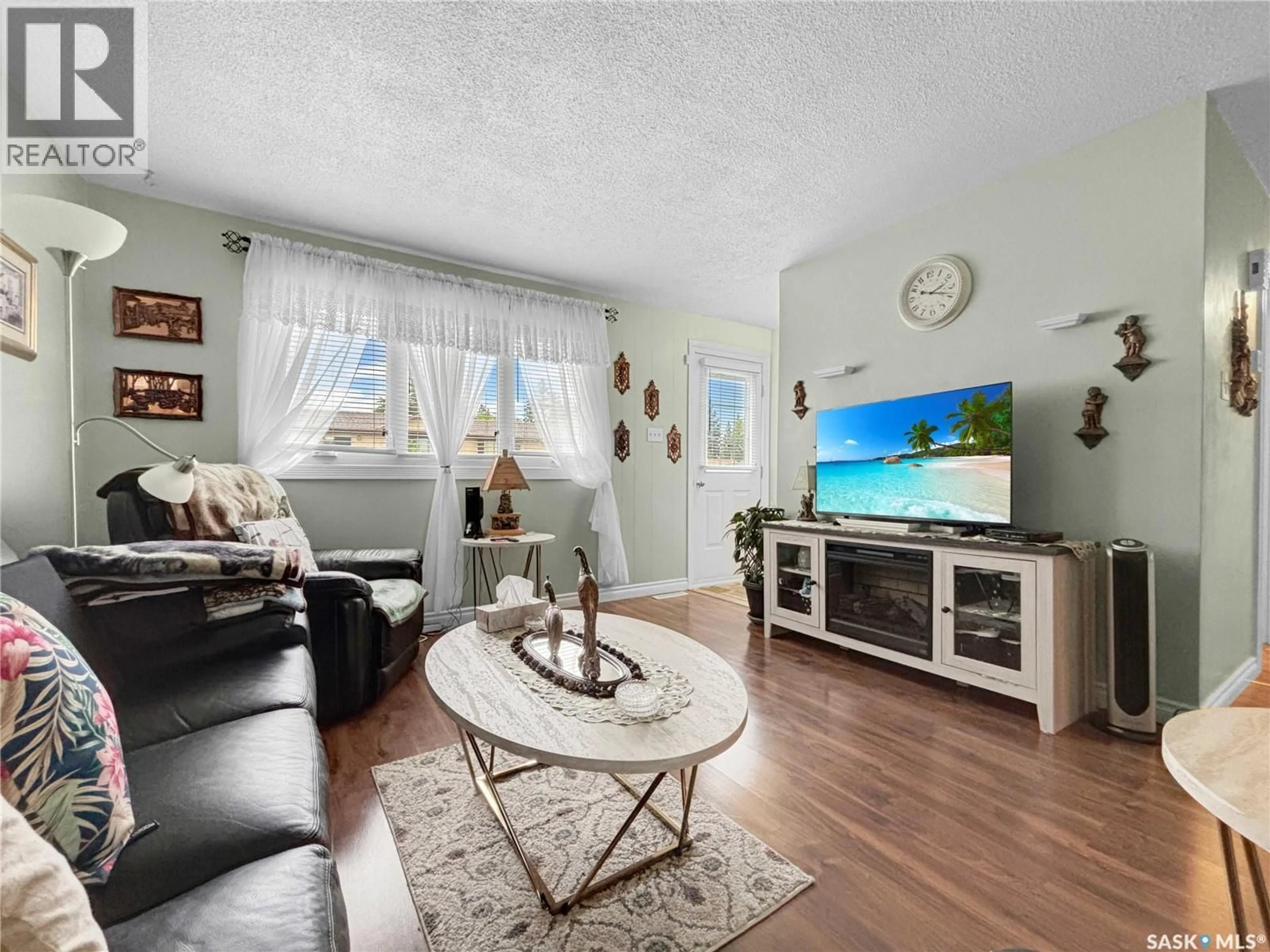 Living room with furniture, wood/laminate floor for 714 S AVENUE N, Saskatoon Saskatchewan S7L3A3