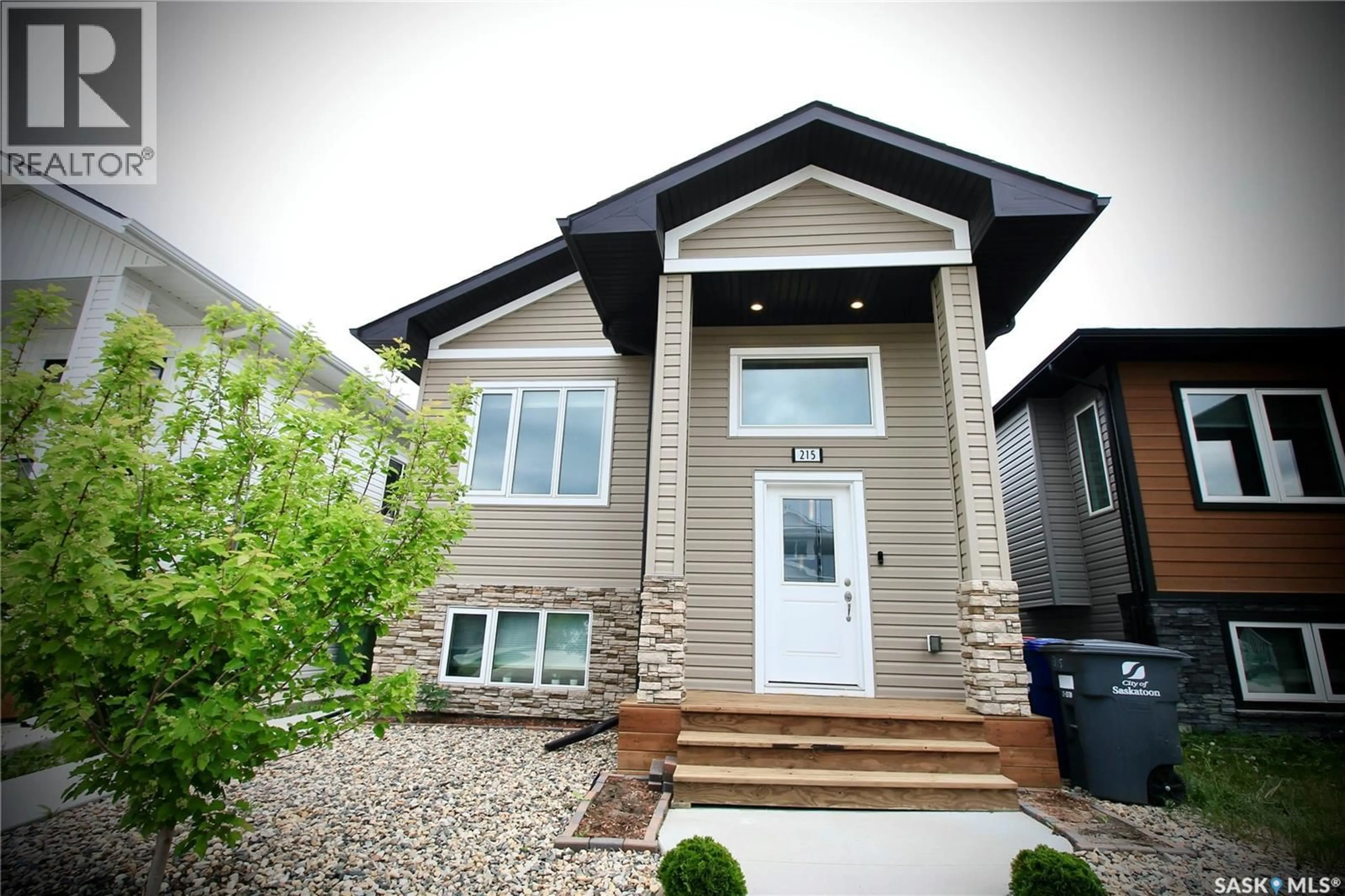 Home with vinyl exterior material, street for 215 THAKUR STREET, Saskatoon Saskatchewan S7W1C4