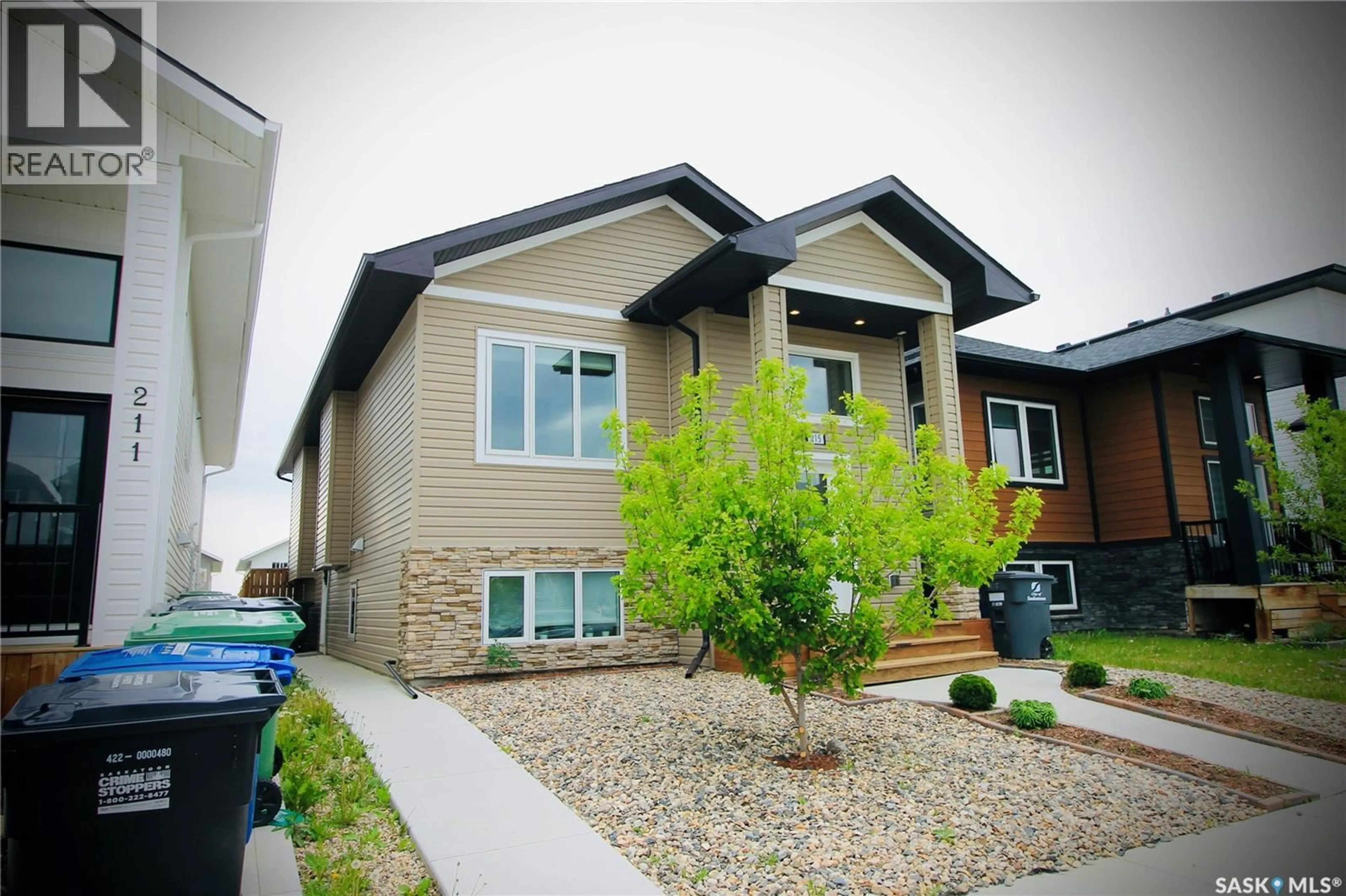 Home with vinyl exterior material, street for 215 THAKUR STREET, Saskatoon Saskatchewan S7W1C4
