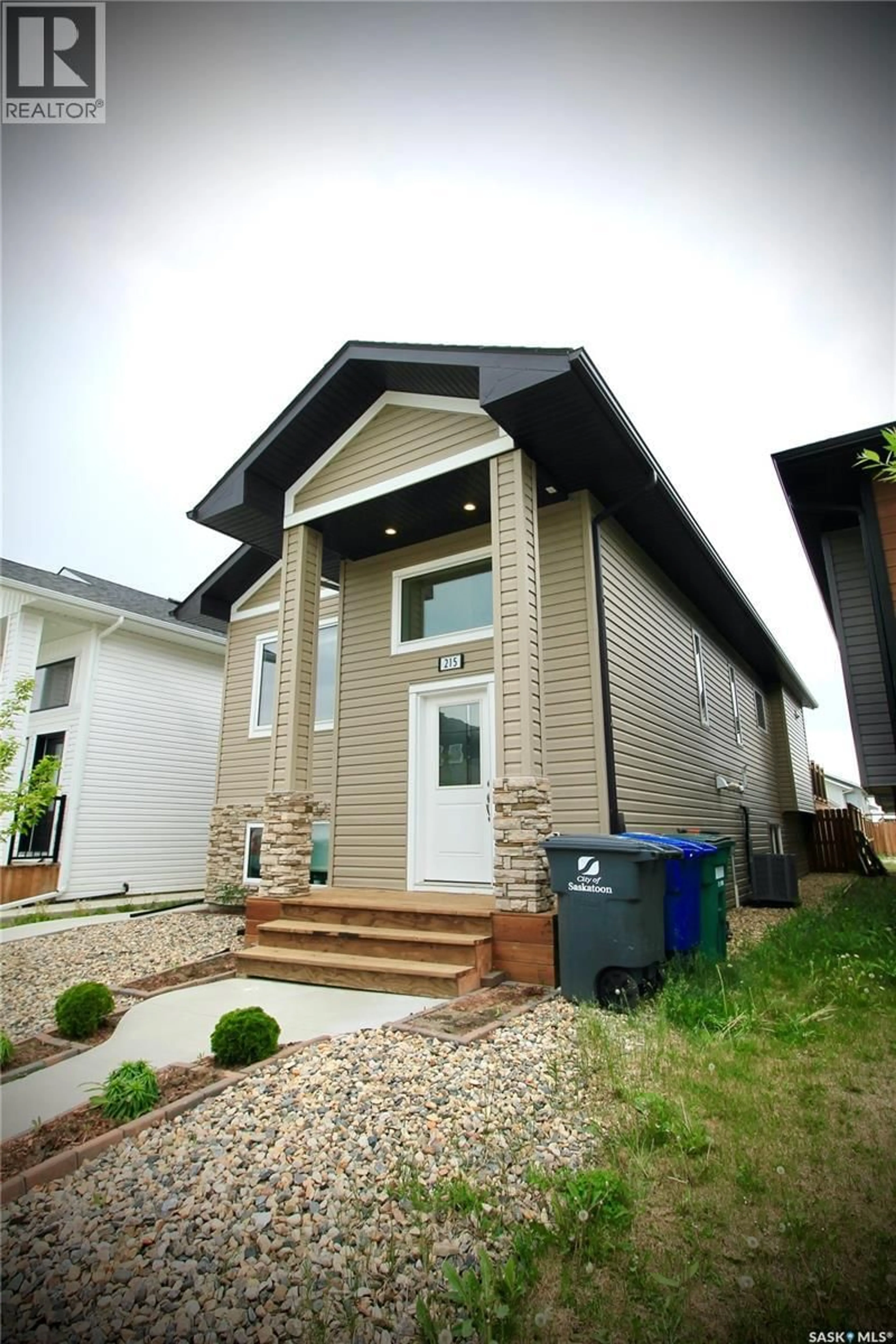 Home with vinyl exterior material, street for 215 THAKUR STREET, Saskatoon Saskatchewan S7W1C4